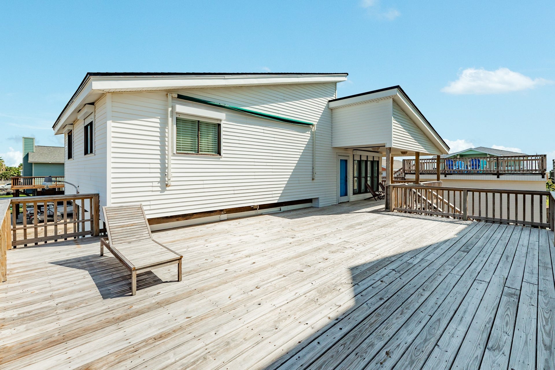 Spacious open-air deck provides flexible room for lounging, outdoor furniture, and entertaining, with direct access to the home's covered porch.