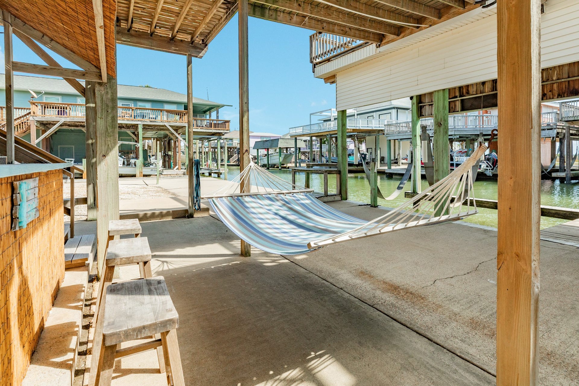 Relax in the shade beneath the home with a hammock overlooking the canal, offering a comfortable spot to unwind after a day on the water.