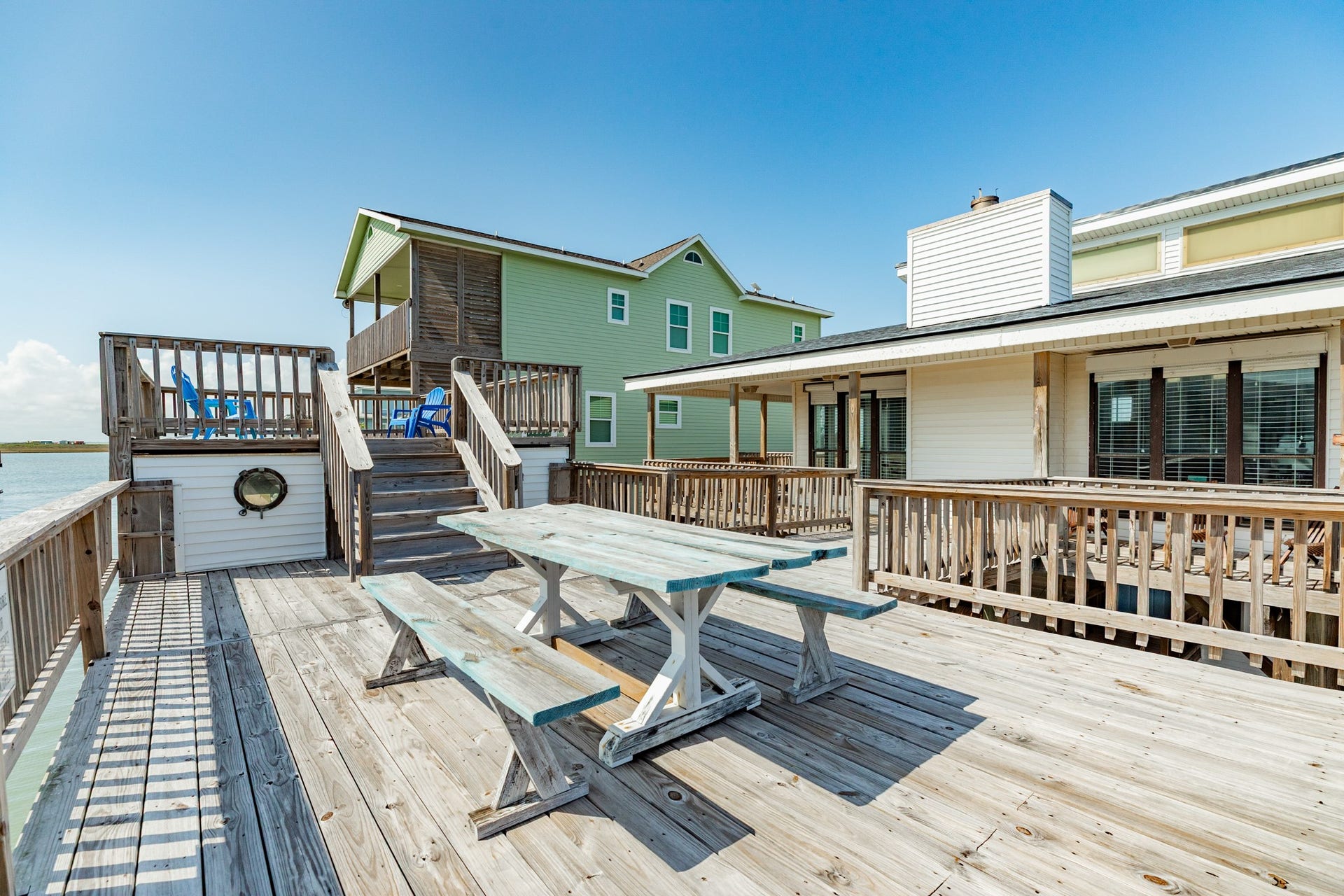 Expansive multi-level deck offers dedicated areas for dining, lounging, and enjoying the outdoors, with convenient stairway access between levels.
