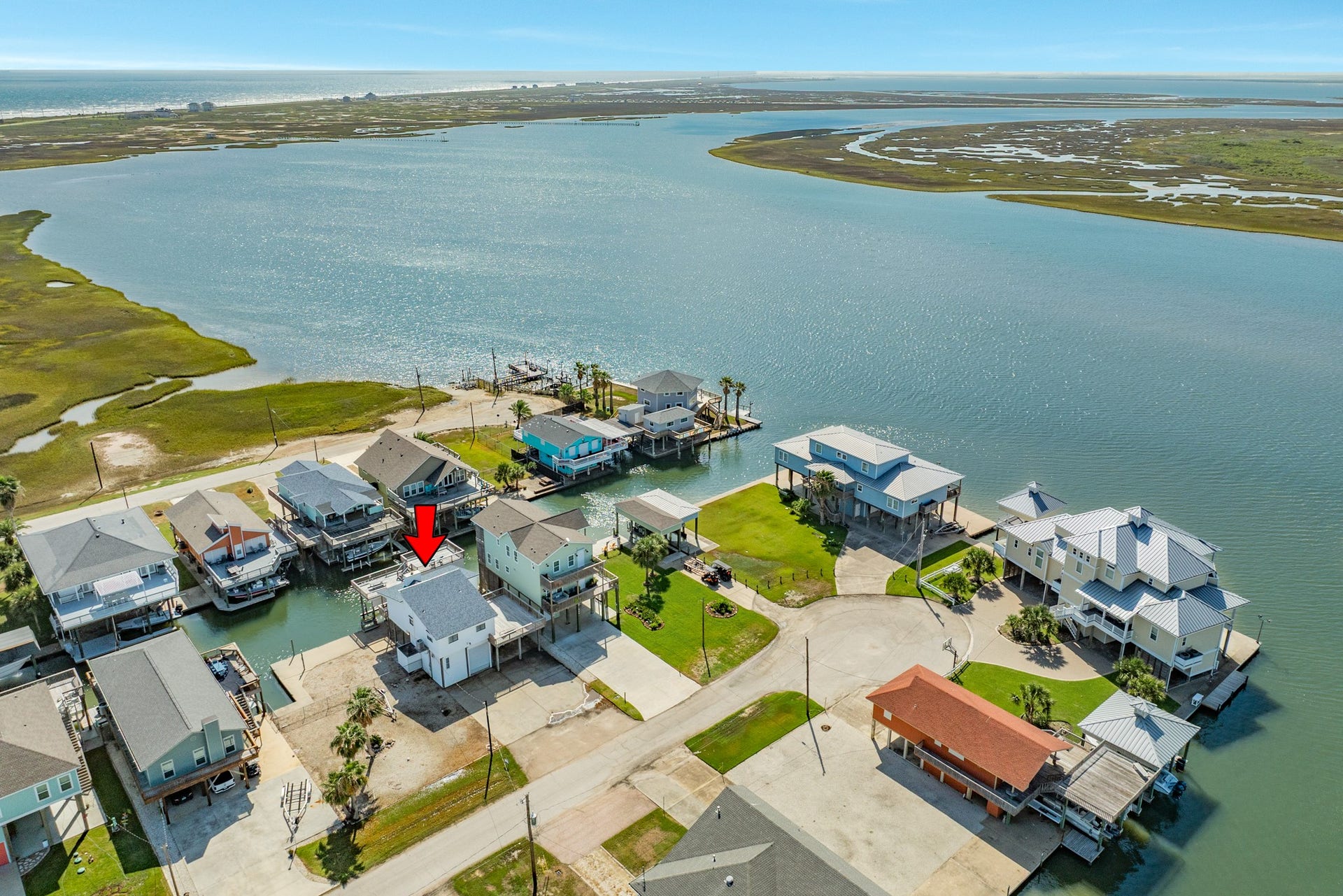 Panoramic view highlights the property's location near expansive coastal wetlands, open bay waters, and the Gulf of Mexico shoreline in the distance.