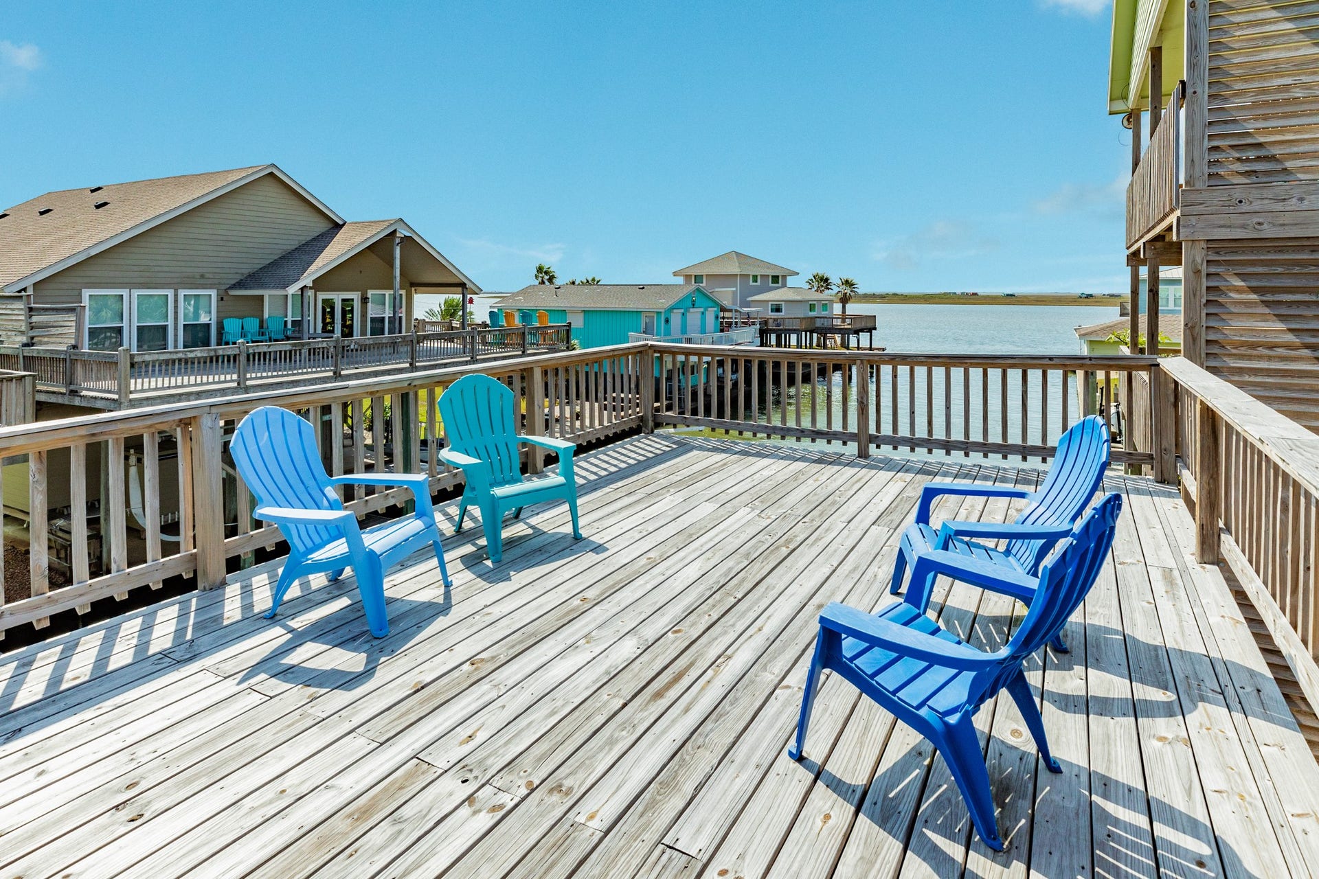 Enjoy coastal breezes and open-water views from this expansive wooden deck, featuring comfortable seating and plenty of space to relax outdoors.