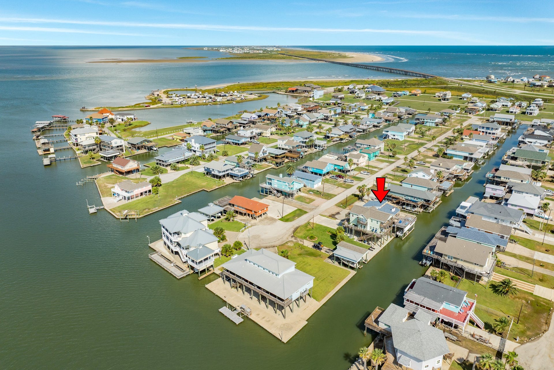 Bird's-eye view captures the property's canal-side location, neighboring waterfront homes, and the surrounding network of waterways.