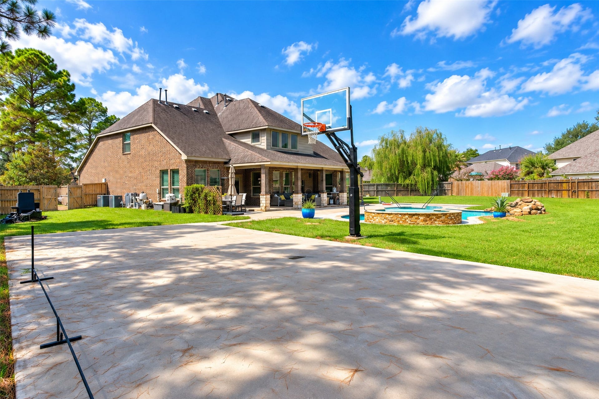 436 Old Orchard Court, Dickinson, TX 77539 Sport court with basketball goal, pool beyond