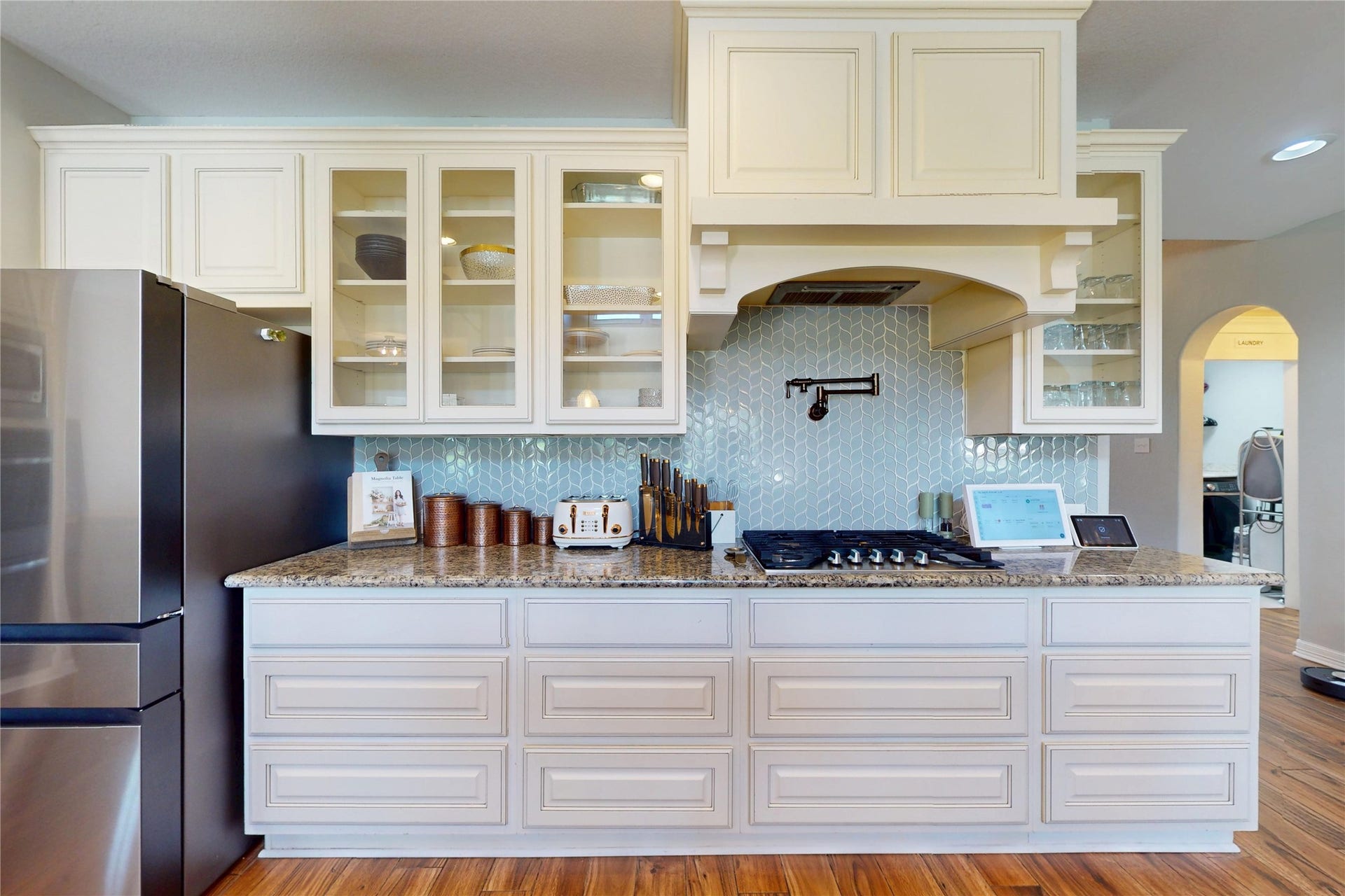 436 Old Orchard Court, Dickinson, TX 77539 Gas cooktop with glass tile backsplash and glass-front cabinetry
