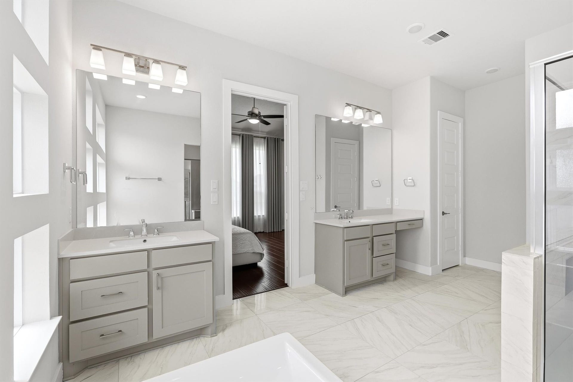 Take in another view of the primary bathroom, featuring two spacious sink vanities that combine practicality with elegant design.