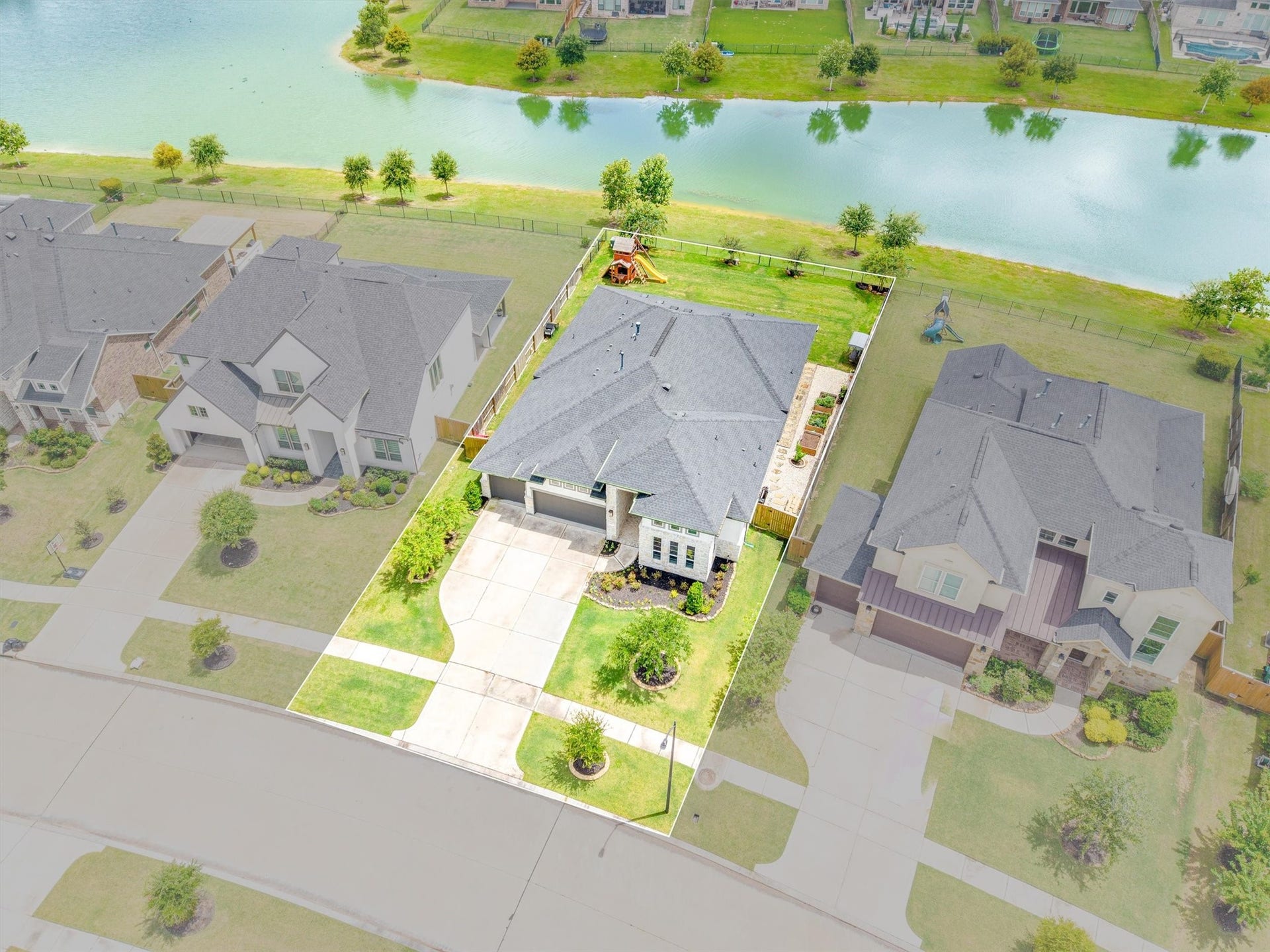 This aerial view of the corner lot showcases the front of the home, highlighting its curb appeal and surrounding property.