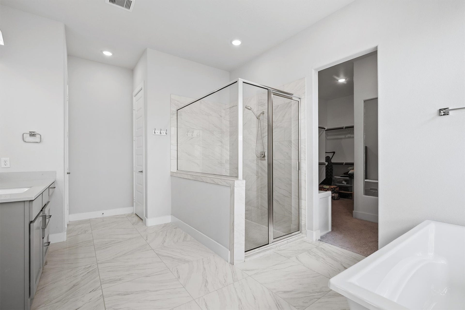 Indulge in the primary bathroom with a luxurious soaking tub and a sleek walk-in shower, creating a modern spa-like retreat right at home.
