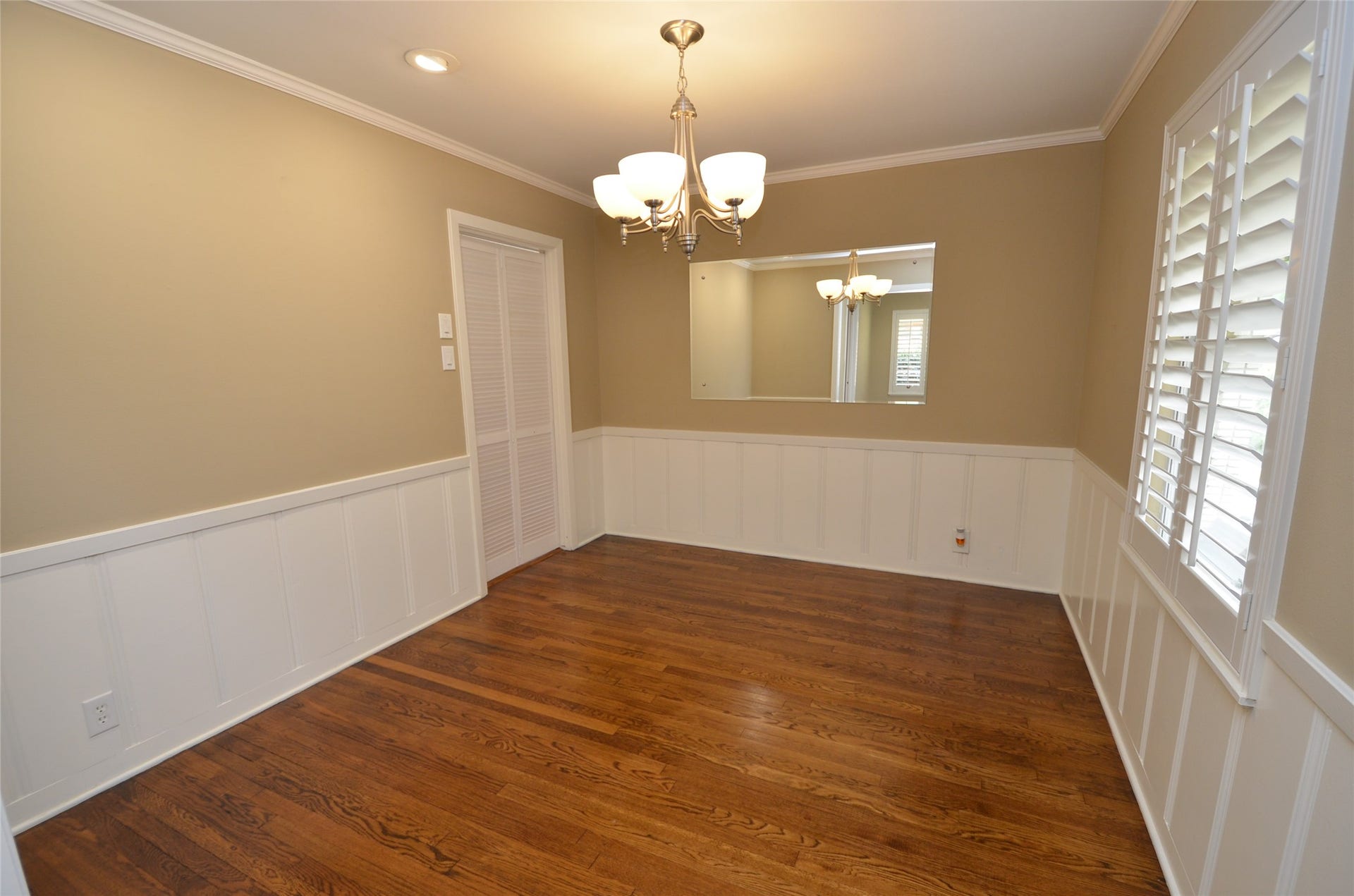 Elegant dining room featuring dimmable recessed lighting and classic wainscoting.