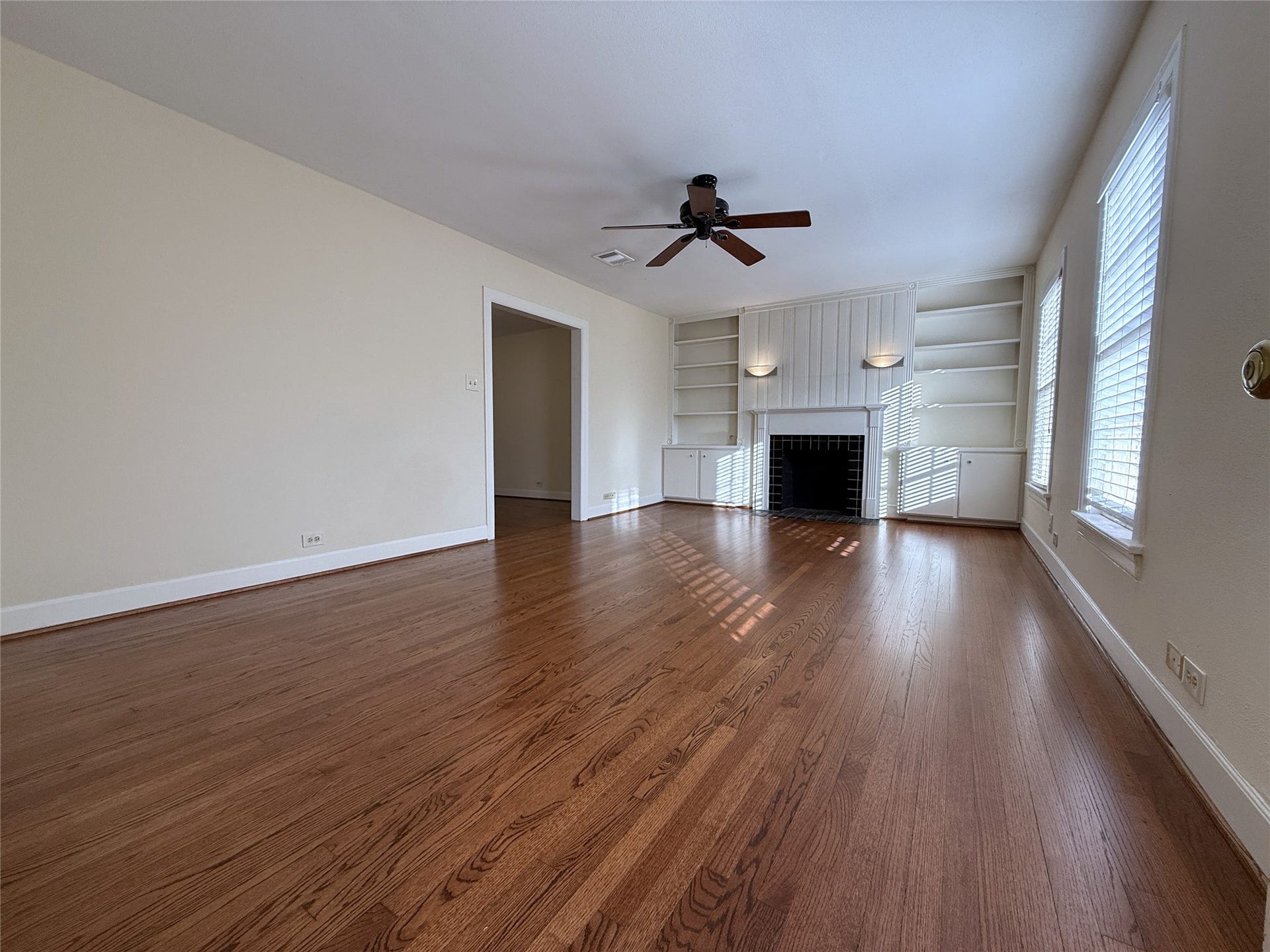 1968 Dryden Road, #2, Houston, TX 77030 Welcome home! The living room offers a ceiling fan, mock fireplace, built-in cabinets/shelving & sconce lighting.