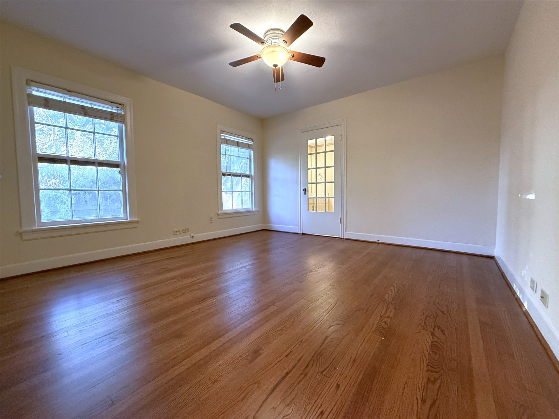 1968 Dryden Road, #2, Houston, TX 77030 The primary bedroom with ceiling fan. Beyond the glass paned door is the primary bathroom.