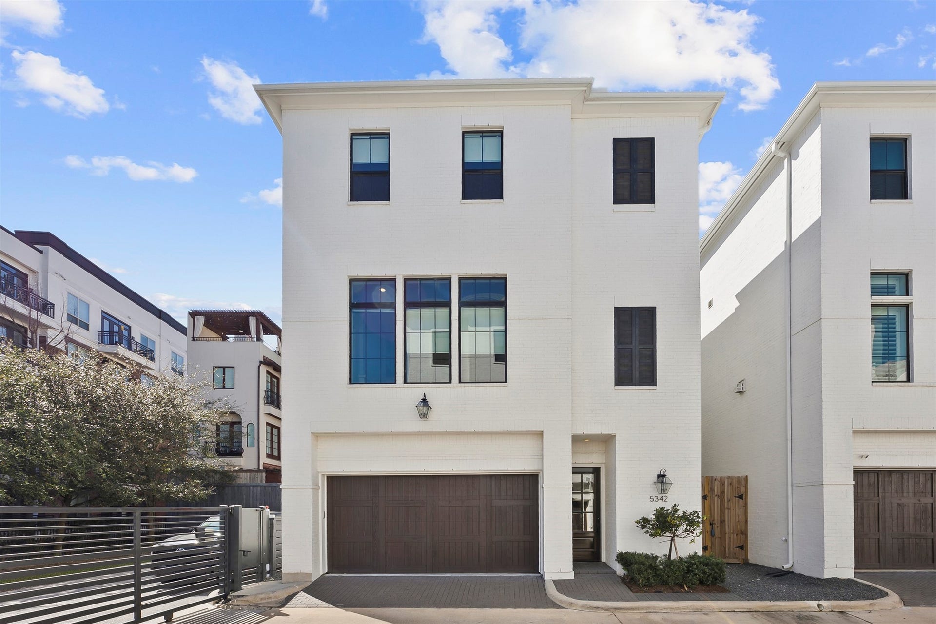Contemporary corner-positioned home in Houston's gated Alys Park community featuring a private driveway, three-car tandem garage, and additional windows that bring abundant natural light throughout the home.