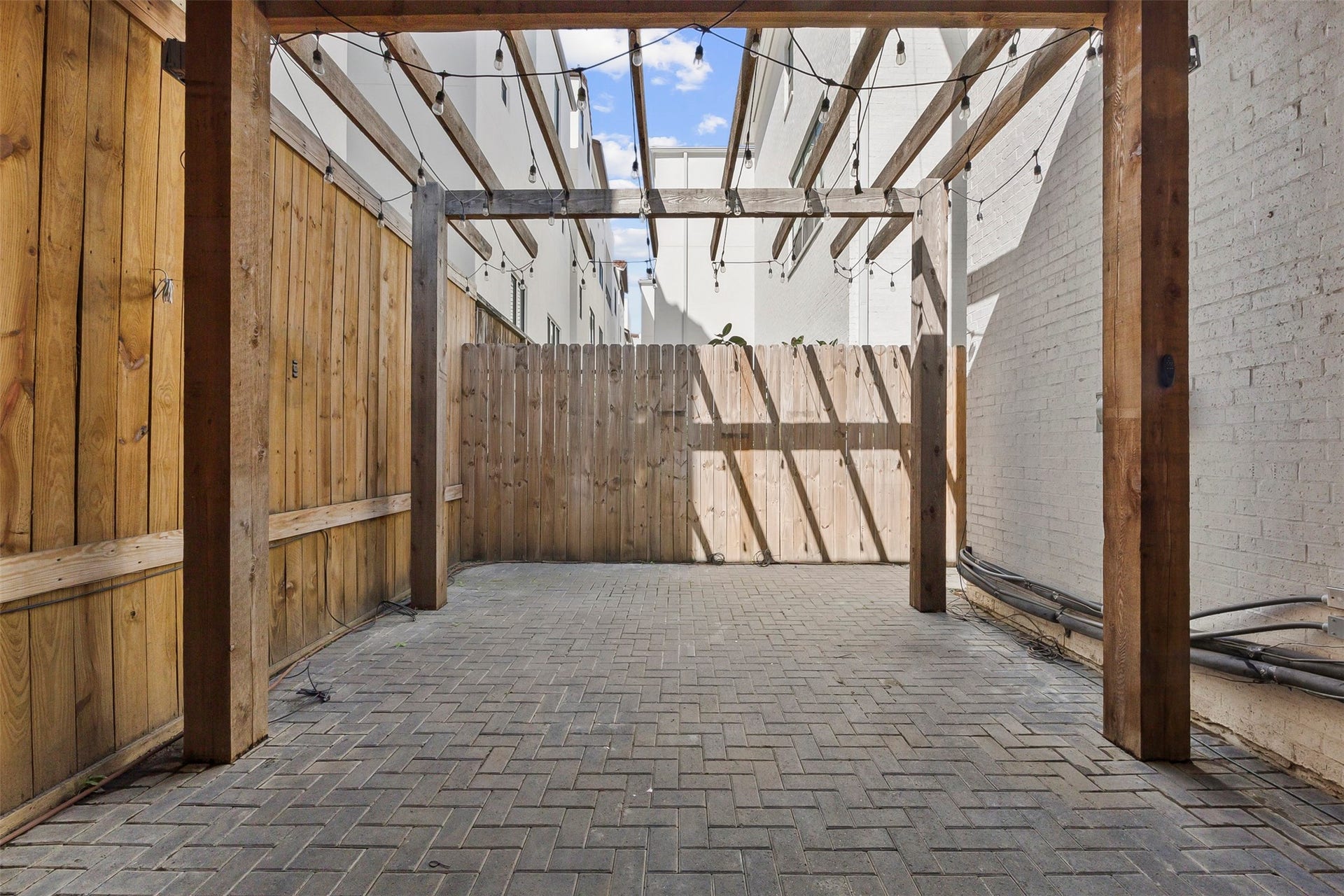 Expansive covered outdoor entertaining area featuring a pergola and flexible gathering space for dining and relaxing.