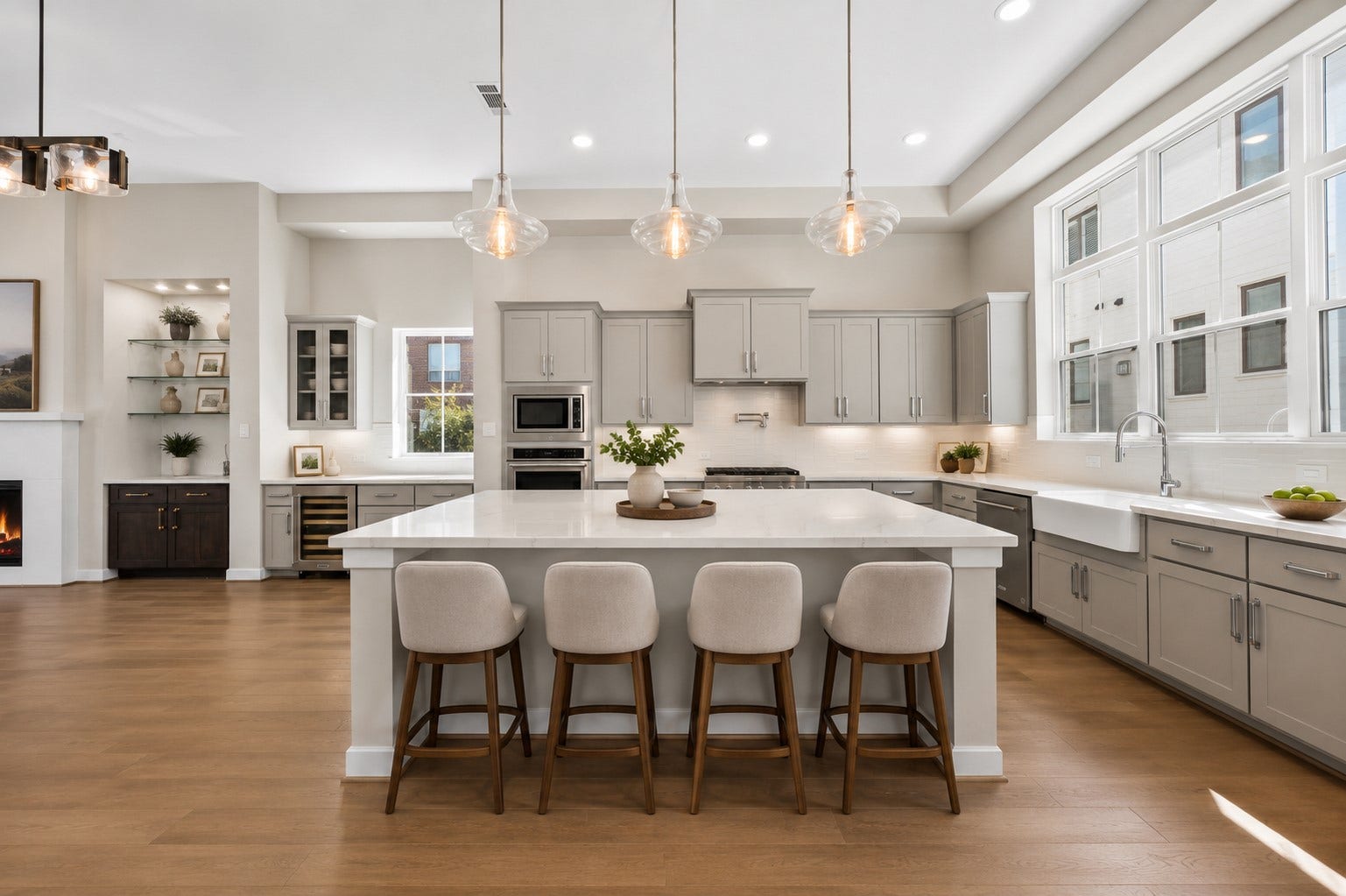 Spacious open-concept kitchen featuring an oversized quartz island with seating, abundant cabinetry, stainless steel appliances, and an ideal layout for everyday living and entertaining.