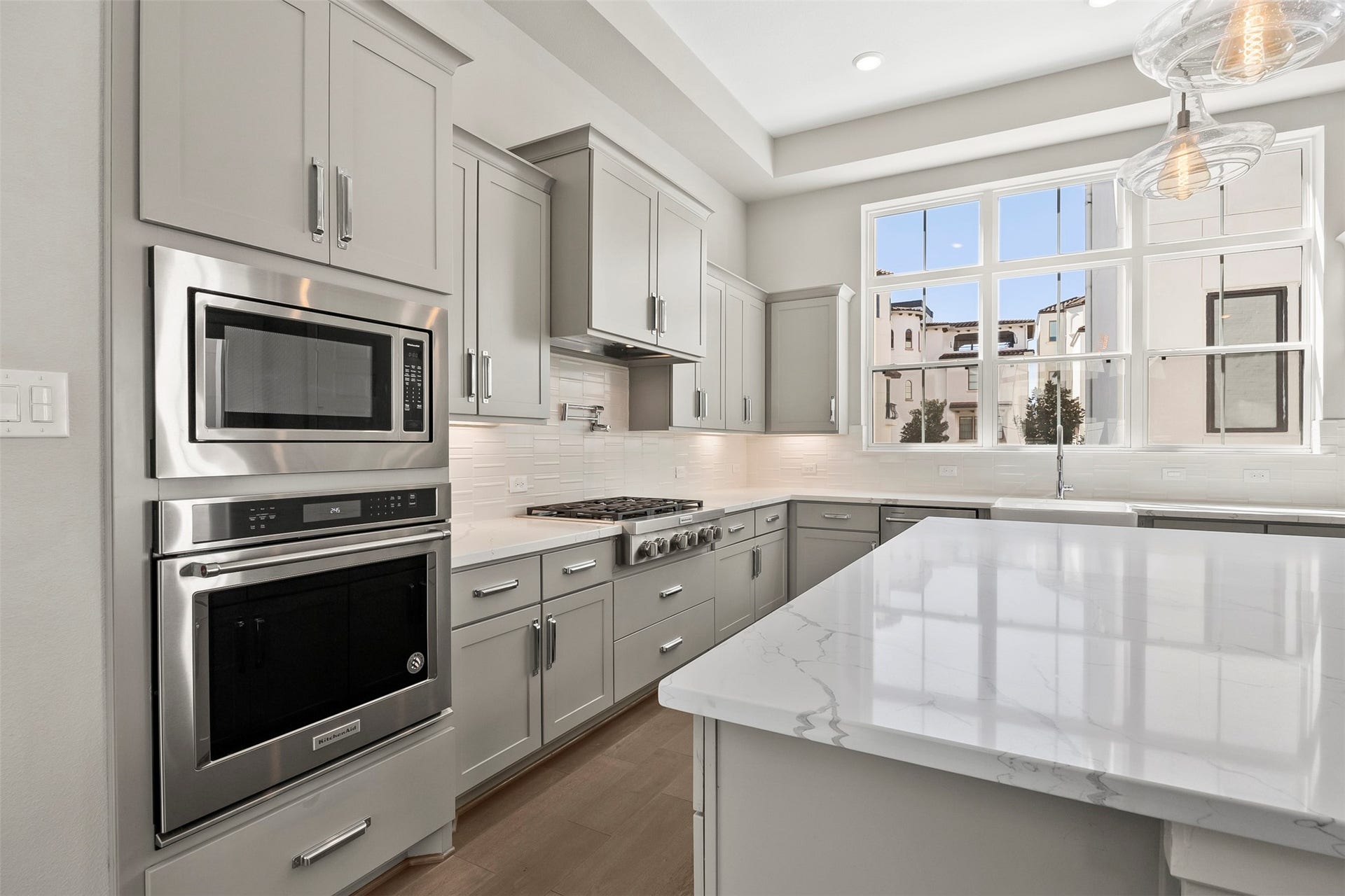 Additional kitchen perspective highlighting stainless steel appliances, quartz countertops, and generous storage throughout.