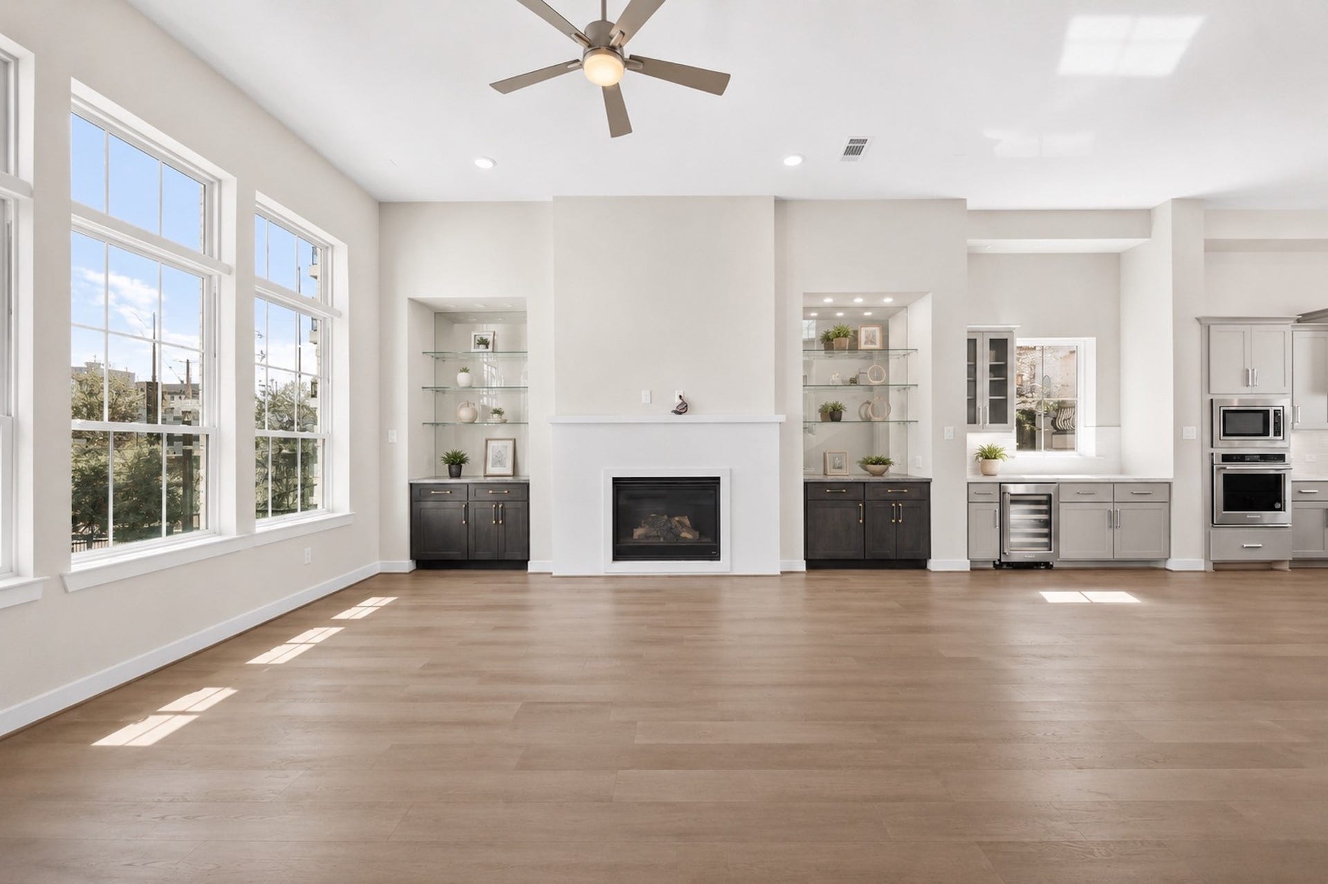 Bright second-floor living area with expansive windows, wood flooring, and abundant natural light from the home's corner position.
