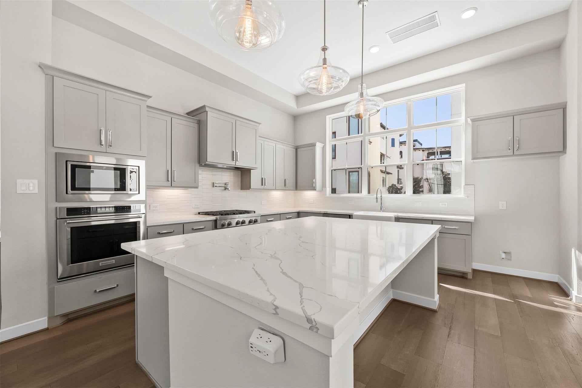 Clean-lined kitchen featuring quartz countertops, modern cabinetry, under-cabinet lighting, and an efficient layout for cooking and entertaining.