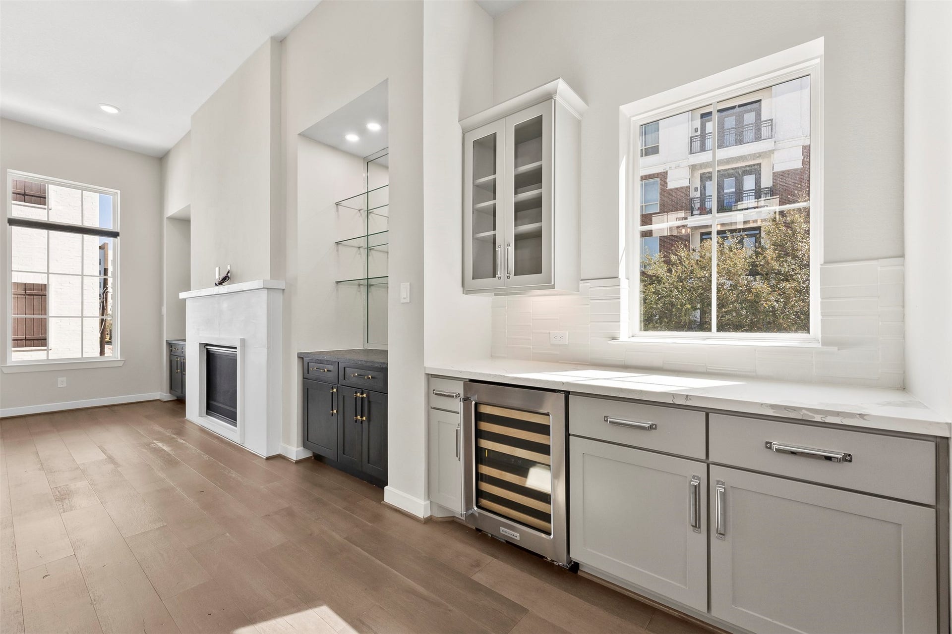 Built-in beverage station and additional cabinetry provide convenient storage and serving space within the open-concept living area.