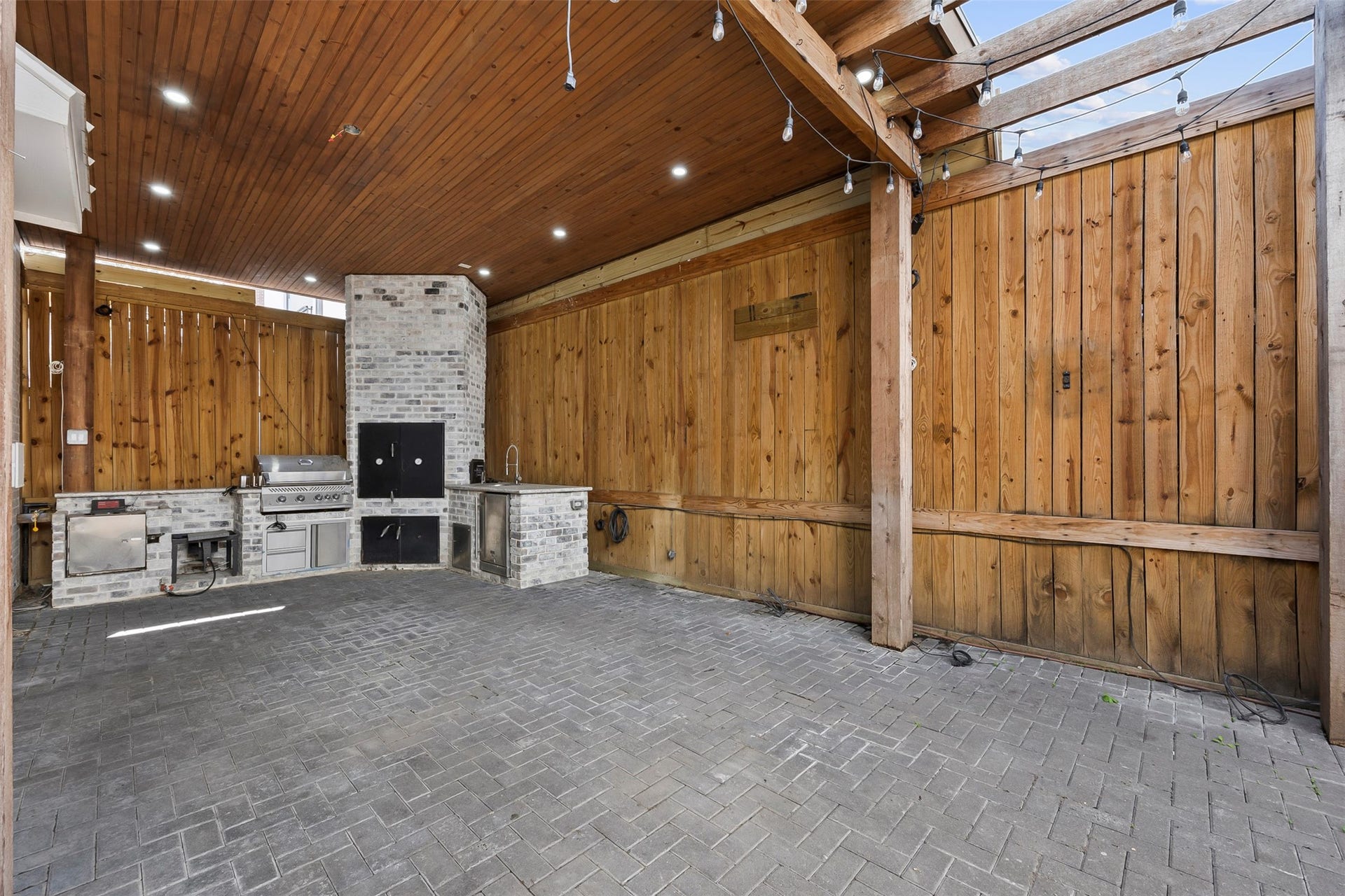 Additional view of the covered outdoor living area highlighting the generous entertaining space and direct connection to the outdoor kitchen.