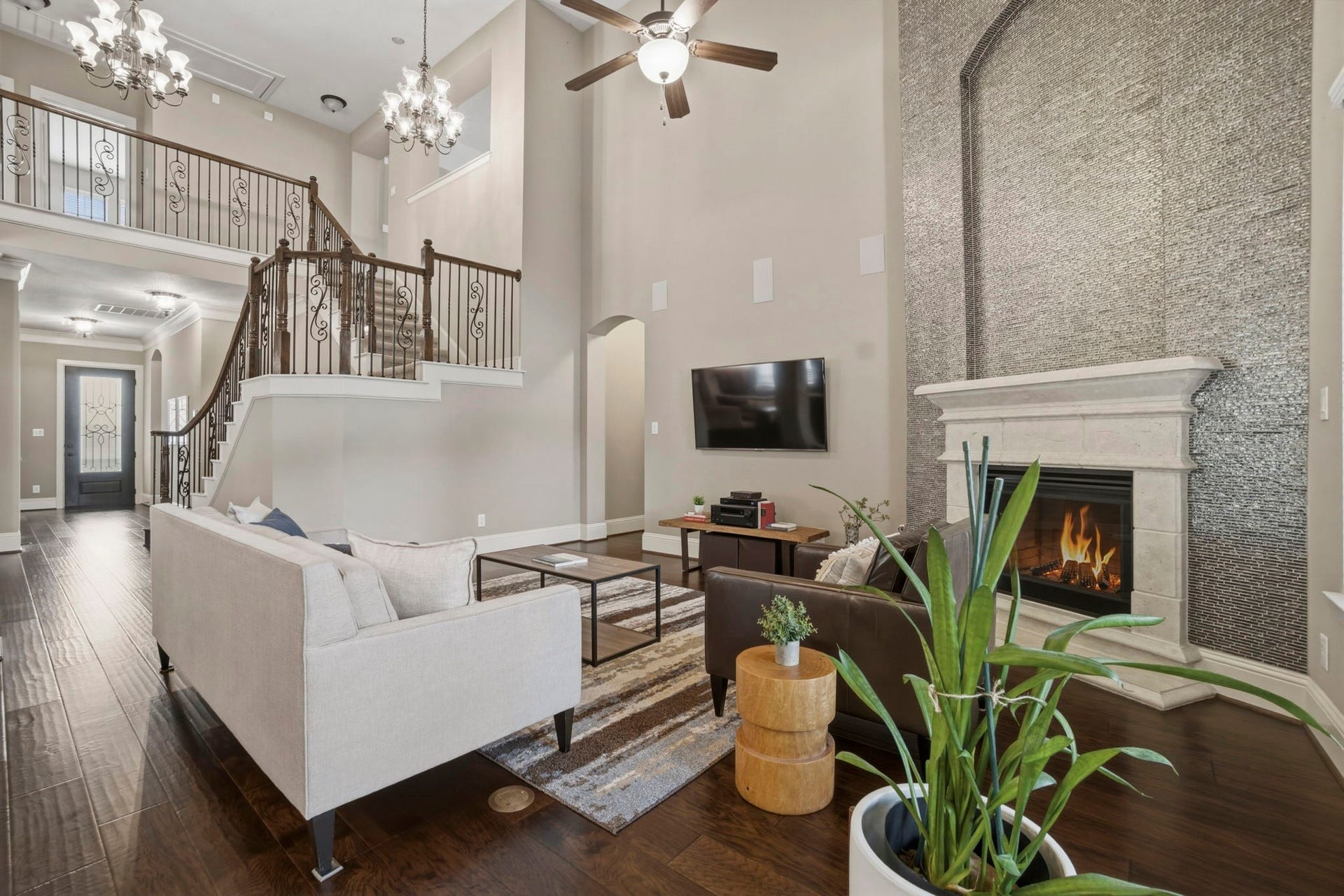 75 W Sawyer Ridge Drive, The Woodlands, TX 77389 Family room features a floor to ceiling fireplace, hardwood floors and an elegant wood and wrought iron staircase with balcony.