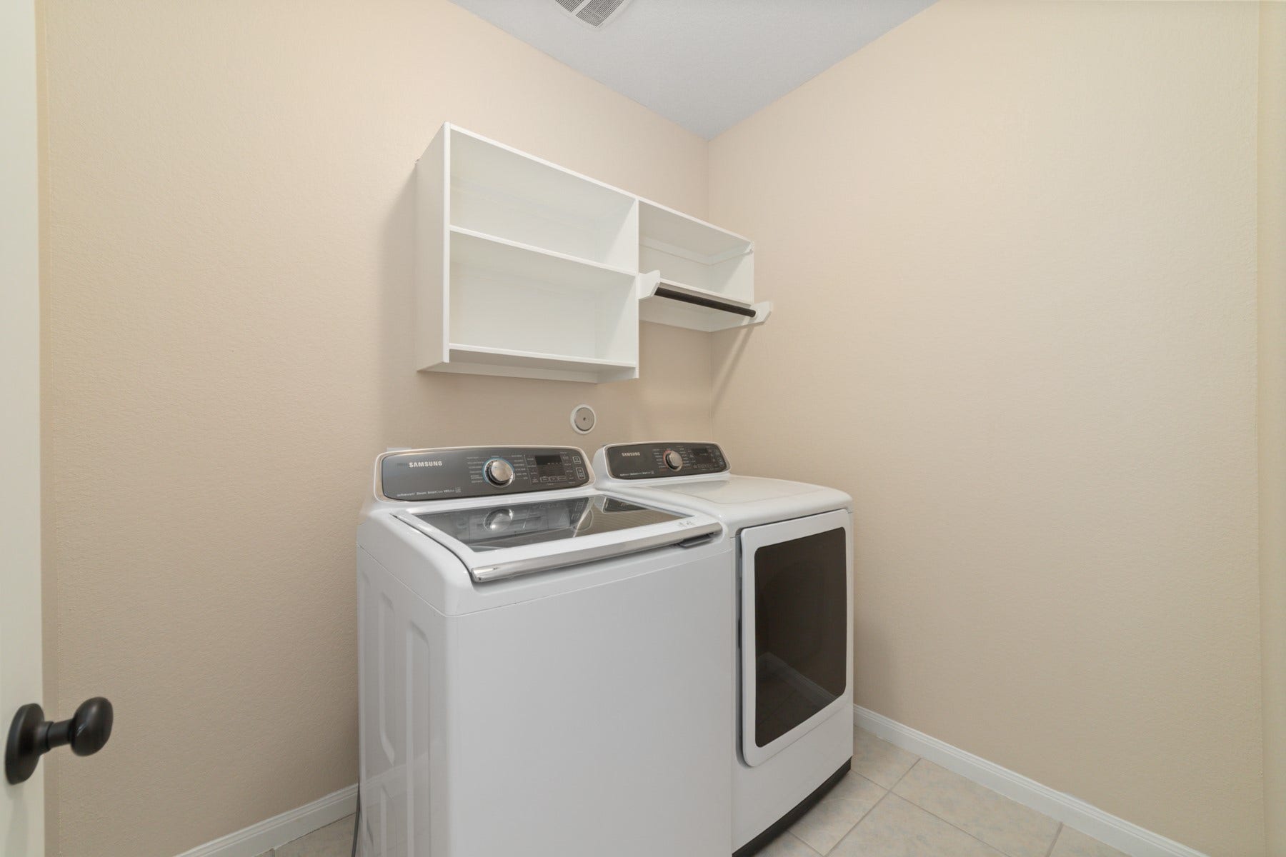 17302 Milrig Court, Richmond, TX 77407 Efficiently designed utility room equipped with modern appliances and ample shelving, perfect for streamlined laundry tasks.
