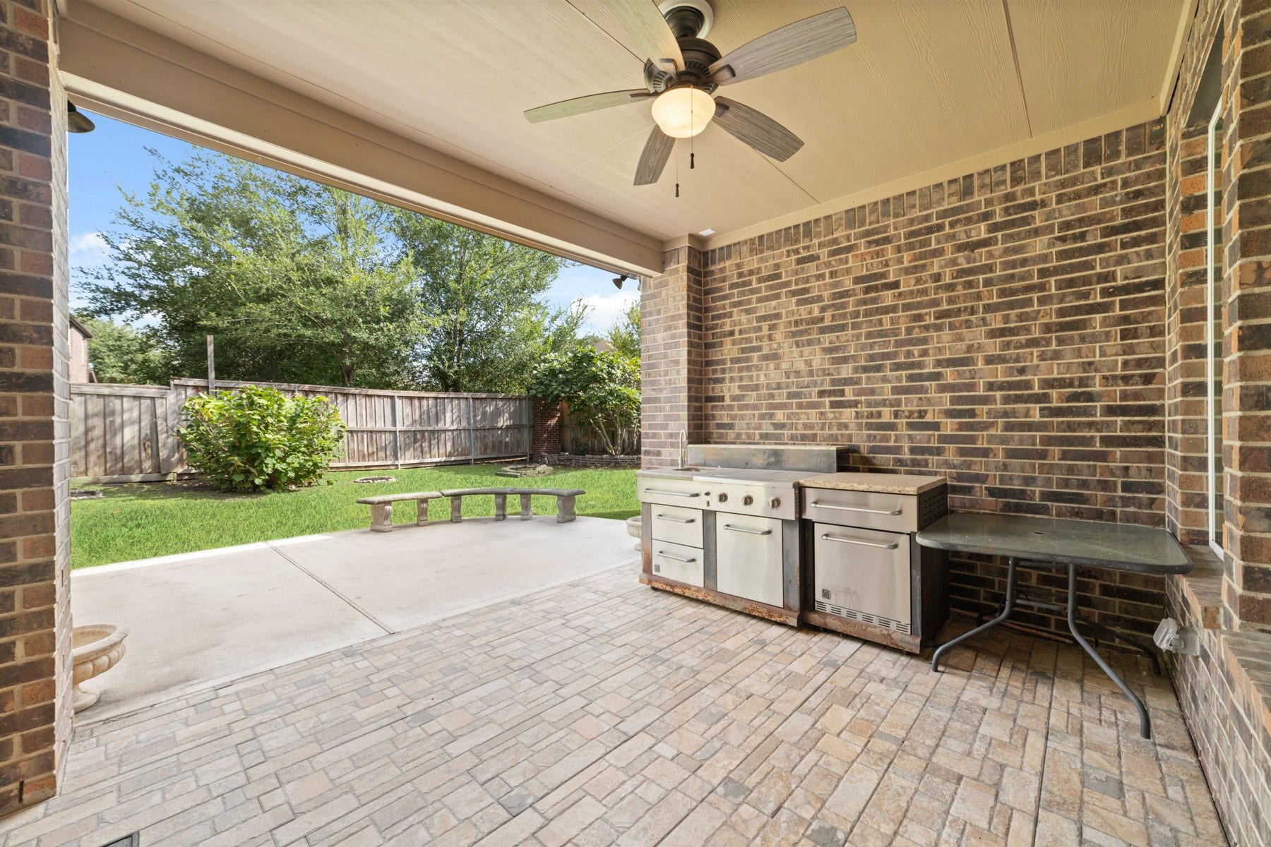 17302 Milrig Court, Richmond, TX 77407 Experience outdoor living at its finest with this spacious covered patio, perfect for entertaining and enjoying serene backyard views.