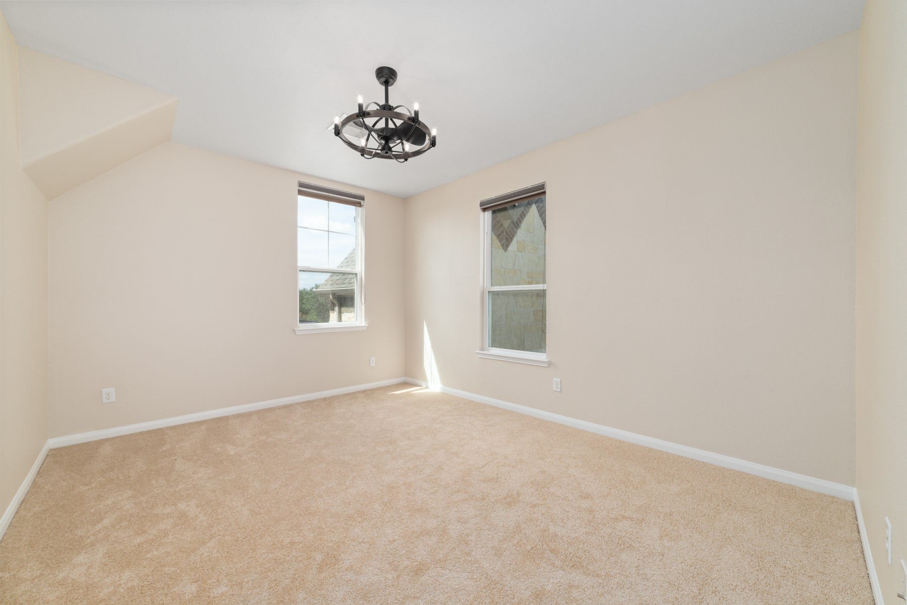 17302 Milrig Court, Richmond, TX 77407 Bedroom #4 offers a cozy retreat with plush carpeting, abundant natural light from dual windows, and a modern chandelier that enhances its inviting ambiance.