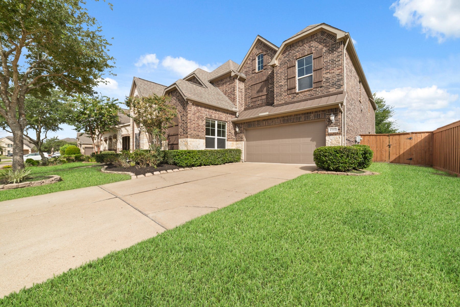 17302 Milrig Court, Richmond, TX 77407 Stunning two-story brick home with a spacious driveway and well-manicured lawn, offering great curb appeal in a serene neighborhood.