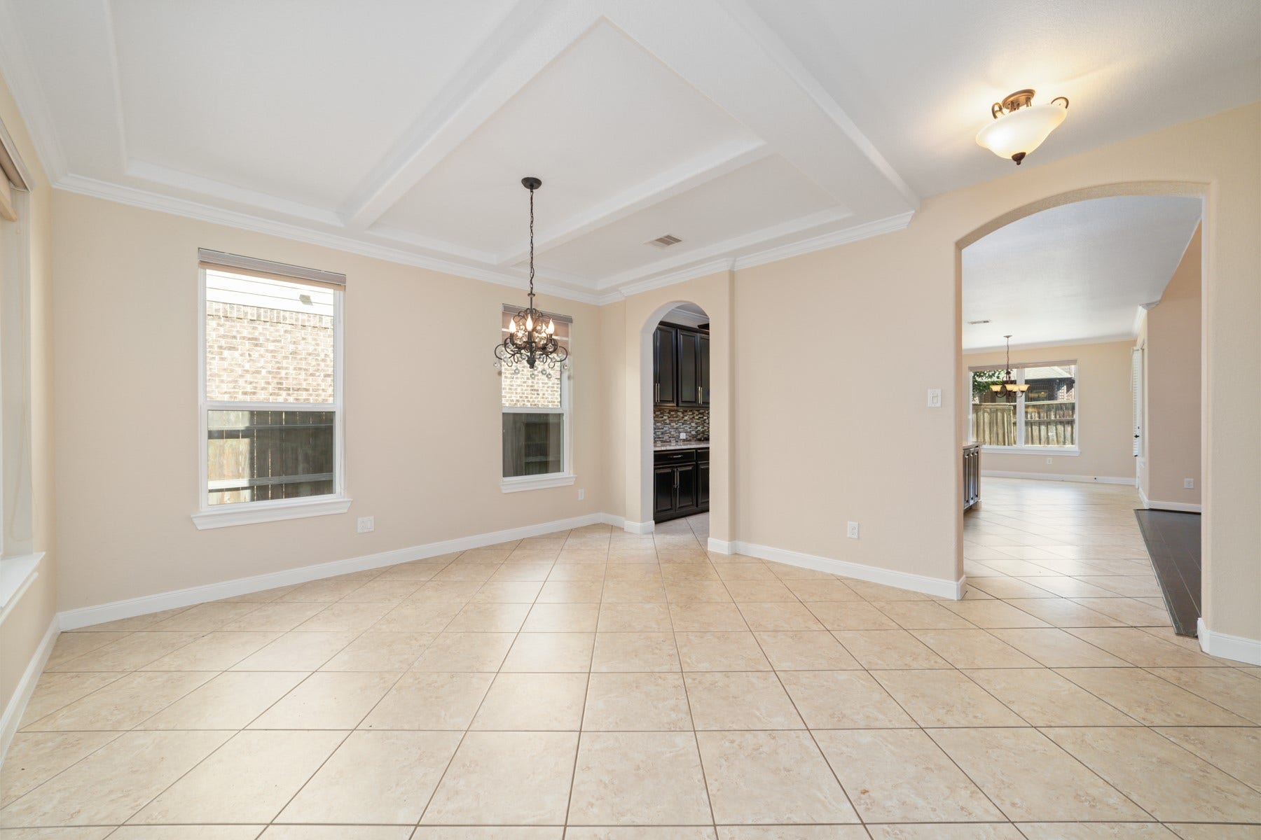 17302 Milrig Court, Richmond, TX 77407 Elegant formal dining room with a coffered ceiling and chic chandelier, perfect for hosting memorable dinner parties.