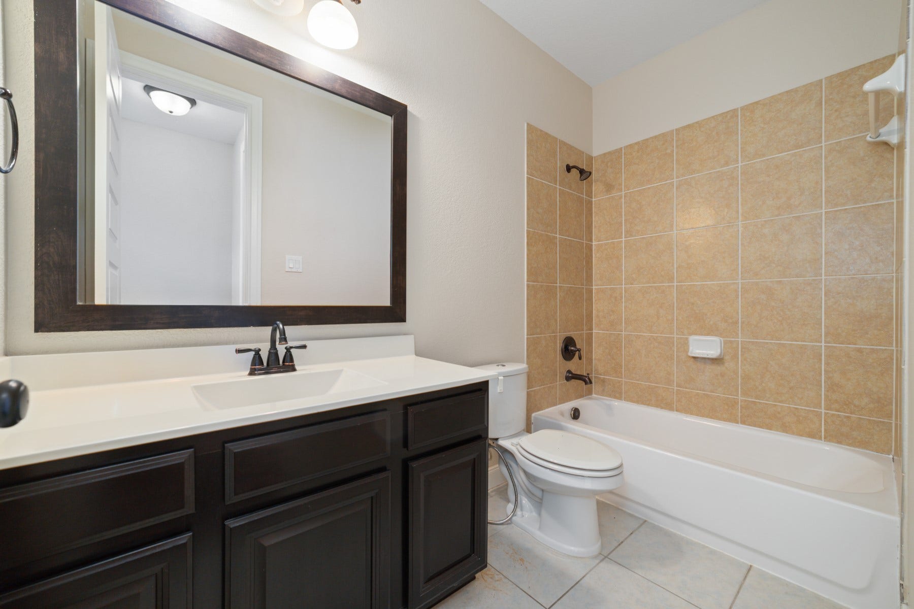 17302 Milrig Court, Richmond, TX 77407 Discover the elegance of this second primary bathroom, featuring a sleek vanity, warm tile accents, and a spacious tub for a relaxing retreat.