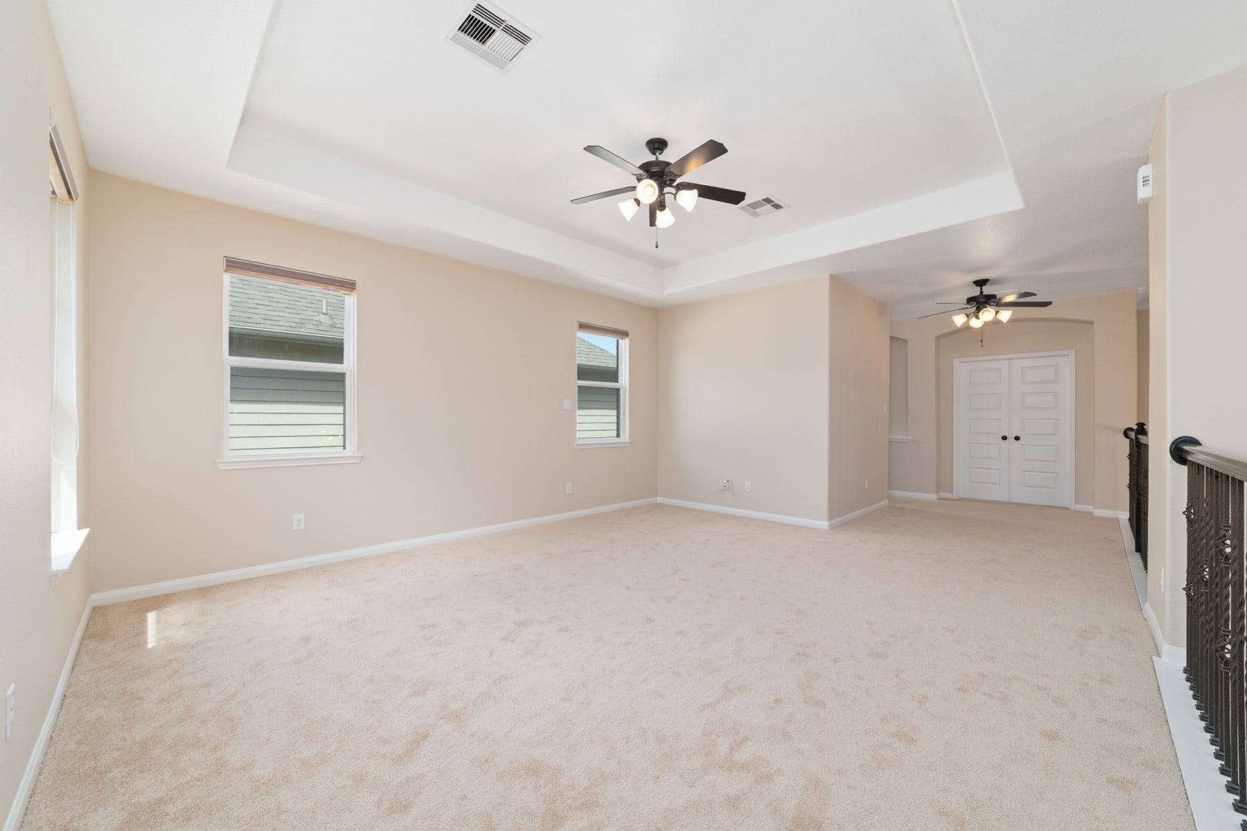 17302 Milrig Court, Richmond, TX 77407 Discover a spacious gameroom perfect for entertainment and relaxation, featuring ample natural light and modern ceiling fans for ultimate comfort.