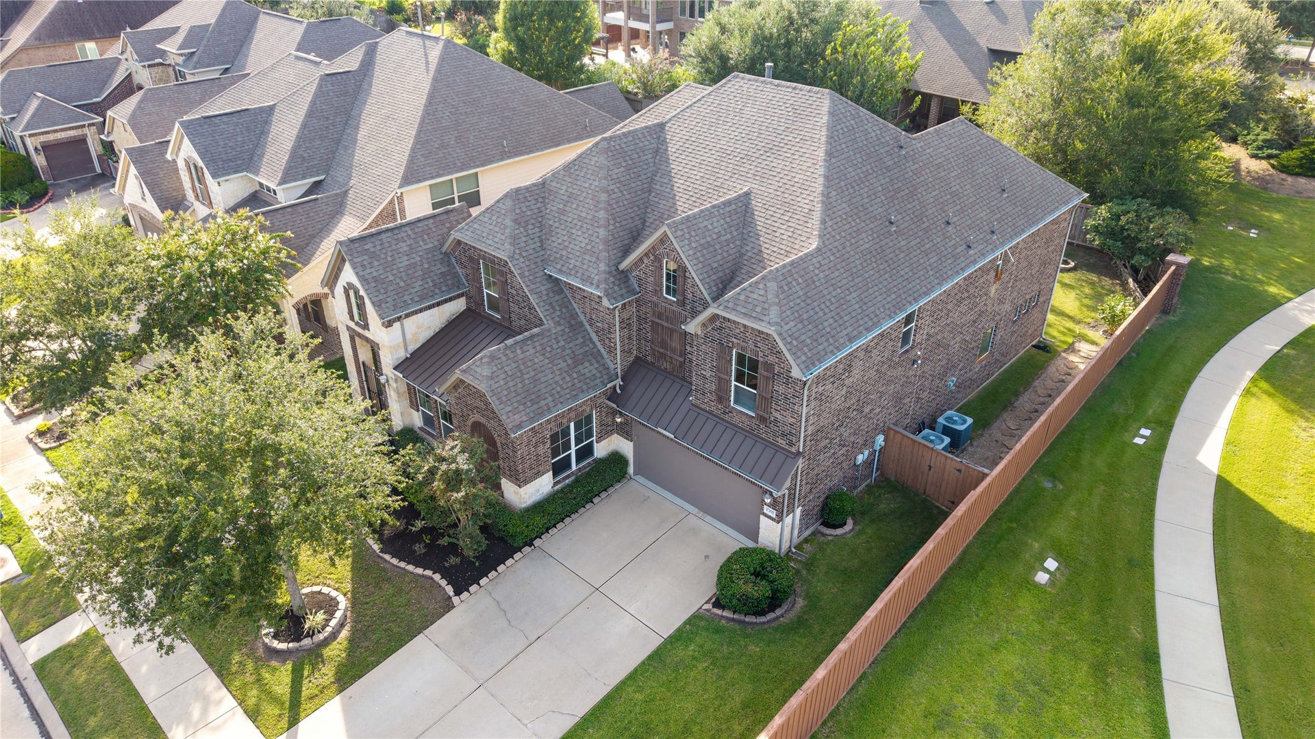 17302 Milrig Court, Richmond, TX 77407 Charming two-story brick home with a spacious driveway and lush greenery, nestled in a serene neighborhood.