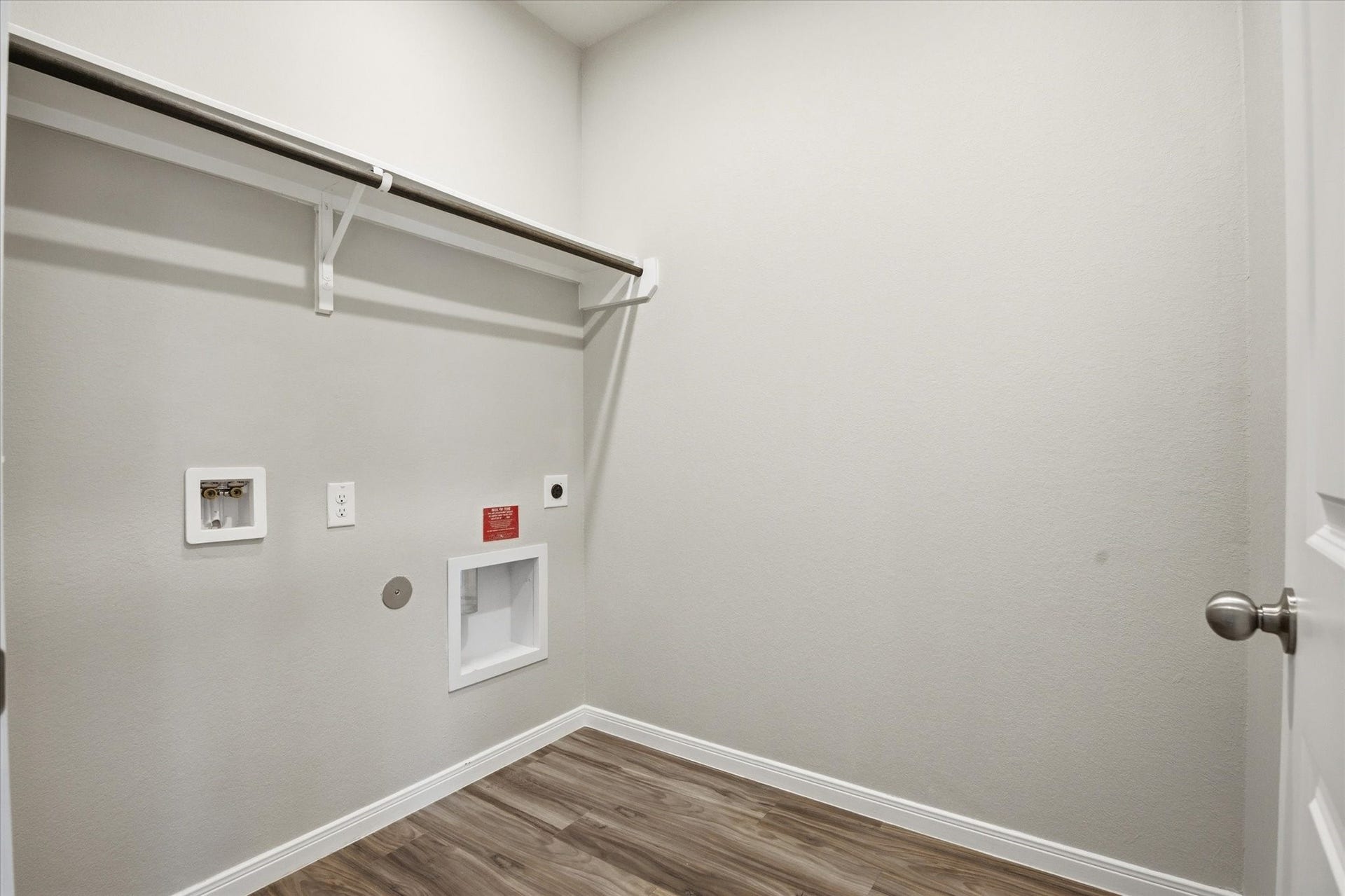 This bright and spacious laundry room offers modern convenience with ample hanging space, making laundry days a breeze.
