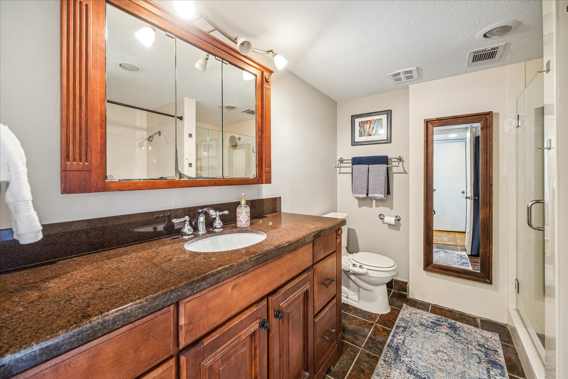 Nice primary bath with granite counters and tile floors.