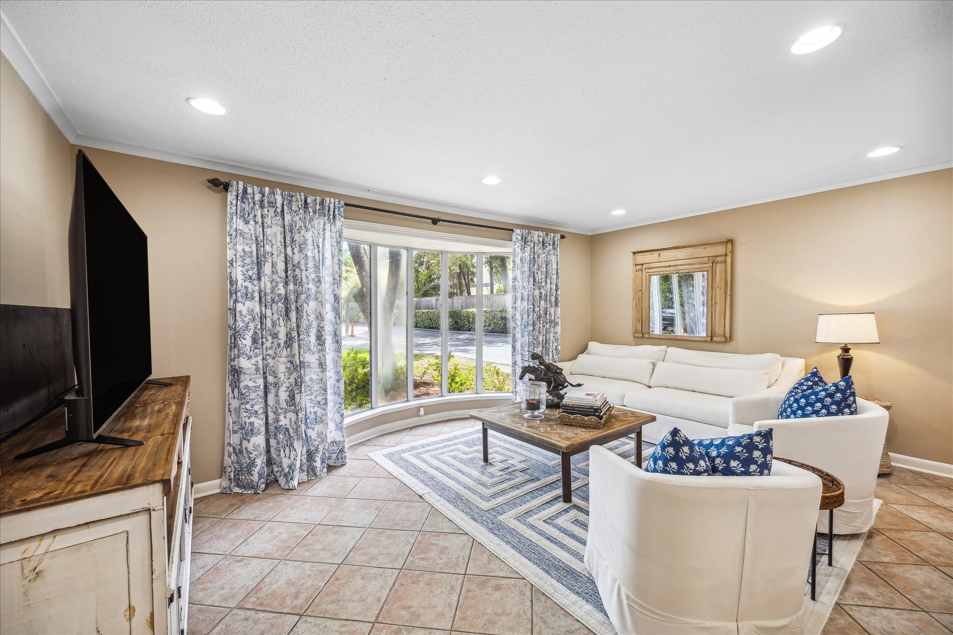 Light and airy living room with tile floors and canned lighting.