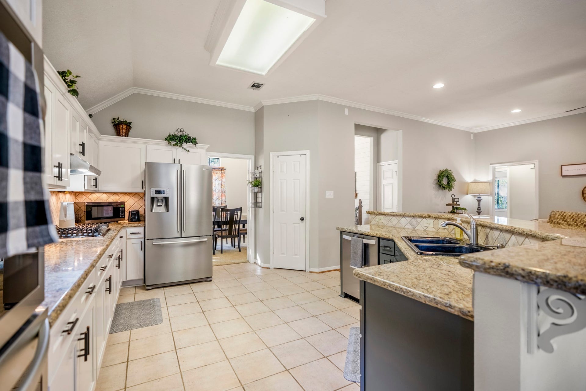 812 Woodland Lane, Conroe, TX 77302 The kitchen features granite countertops, stainless appliances, abundant cabinetry and plenty of prep space.