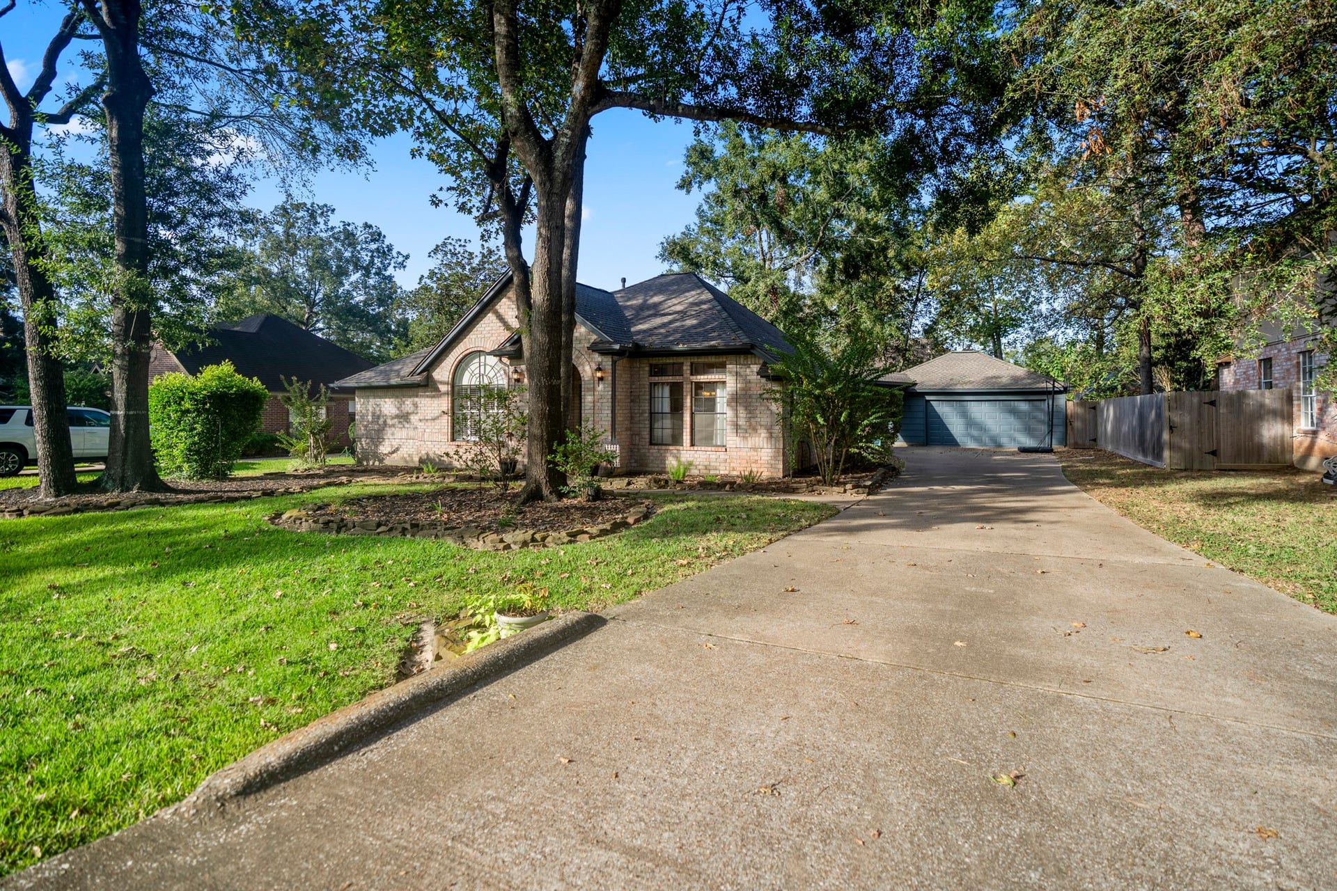 812 Woodland Lane, Conroe, TX 77302 A long driveway with plenty of room to park and play, leading up to an oversized detached garage!