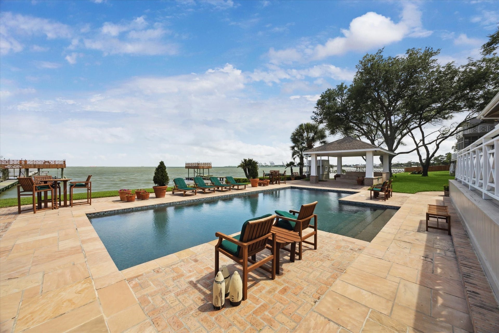 Another view of the pool from the covered outdoor kitchen and dining area outside the main house.