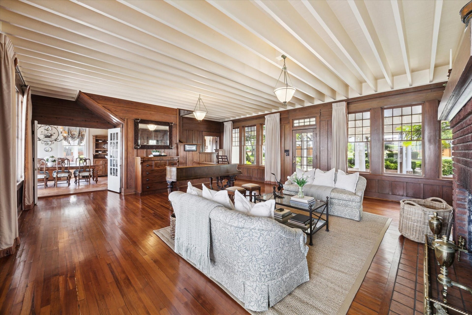 Another view of the living room main house, featuring exposed beams, original hardwood flooring.