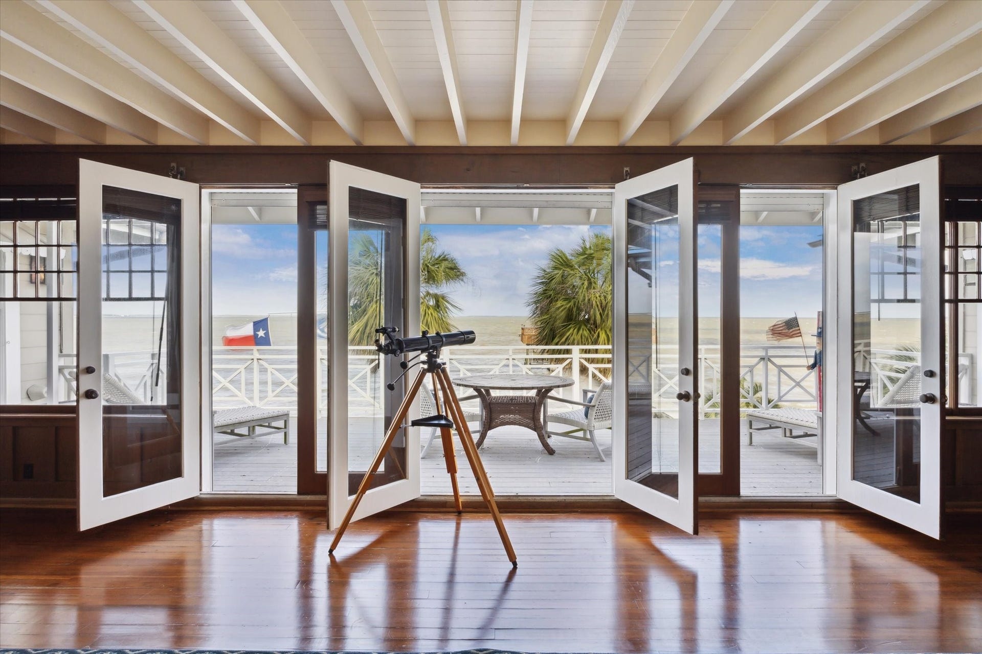 Doors opening to deck and expansive views of lawn, piers and Galveston Bay.