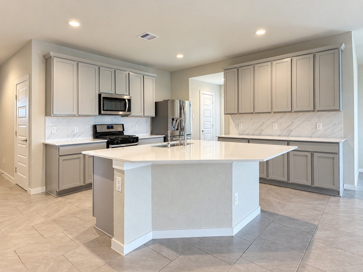 29443 Bryans Manor, Fulshear, TX 77494 Bright, contemporary kitchen featuring a spacious center island, stainless steel appliances, stylish cabinetry, and recessed lighting.