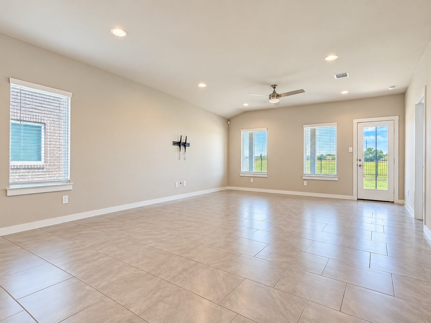 29443 Bryans Manor, Fulshear, TX 77494 Another view of the expansive living space showcasing the open floor plan, modern ceiling fan, and easy access to the backyard.