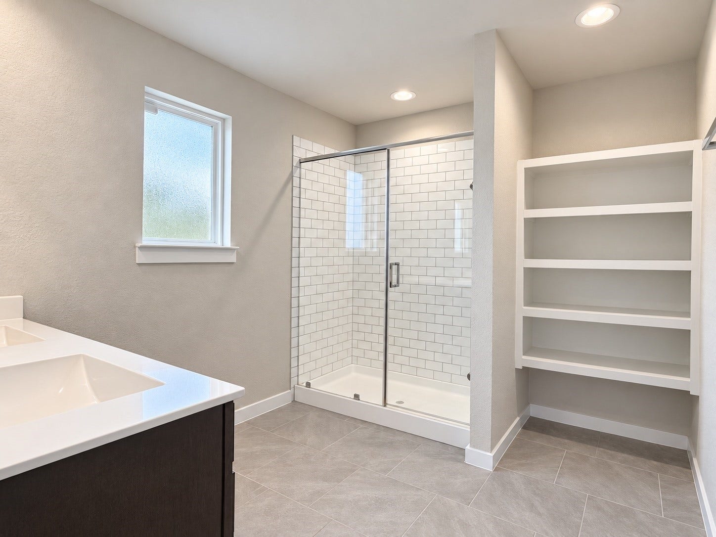 29443 Bryans Manor, Fulshear, TX 77494 Spacious primary bathroom featuring a glass-enclosed shower, built-in shelving, tile flooring, and a window providing natural light.