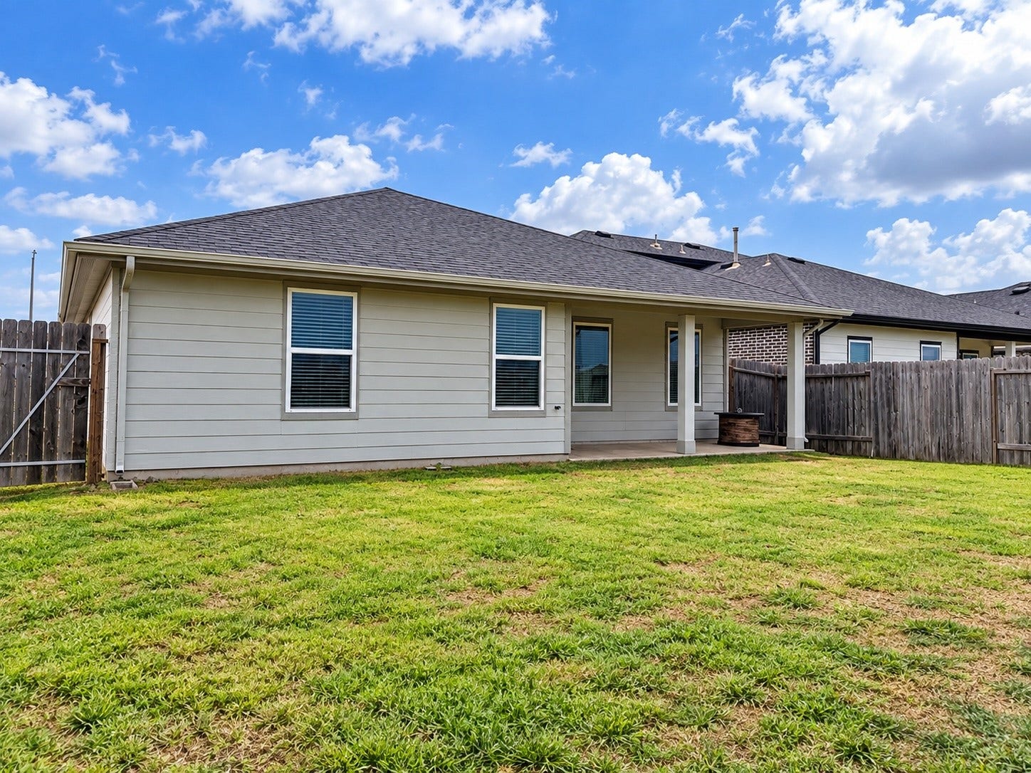 29443 Bryans Manor, Fulshear, TX 77494 Spacious backyard featuring a covered patio, open lawn area, and privacy fencing, offering plenty of room for outdoor enjoyment.