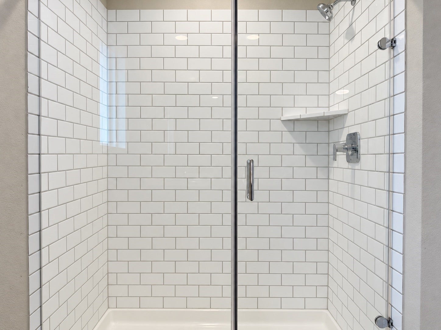 29443 Bryans Manor, Fulshear, TX 77494 Glass-enclosed shower featuring classic white subway tile, chrome fixtures, and a convenient built-in corner shelf.