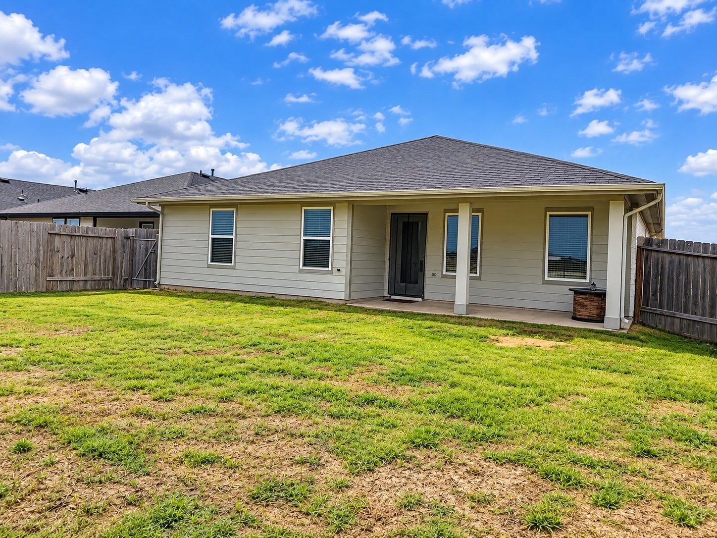 29443 Bryans Manor, Fulshear, TX 77494 Additional view of the home's rear exterior showcasing the covered patio, generous backyard space, and fenced outdoor area.