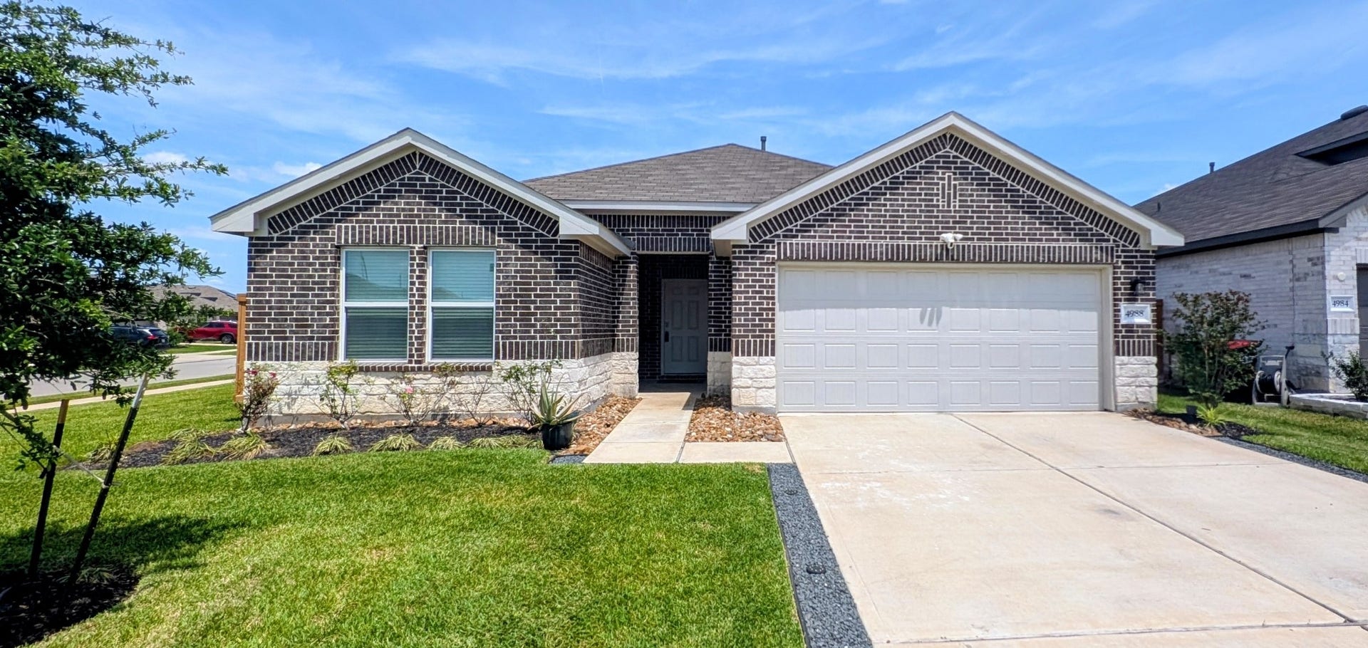 4988 Blue Beetle Ridge Drive, Katy, TX 77493 Discover this charming corner-lot home, showcasing elegant four-sided brick and stone design, complemented by beautiful landscaping.
