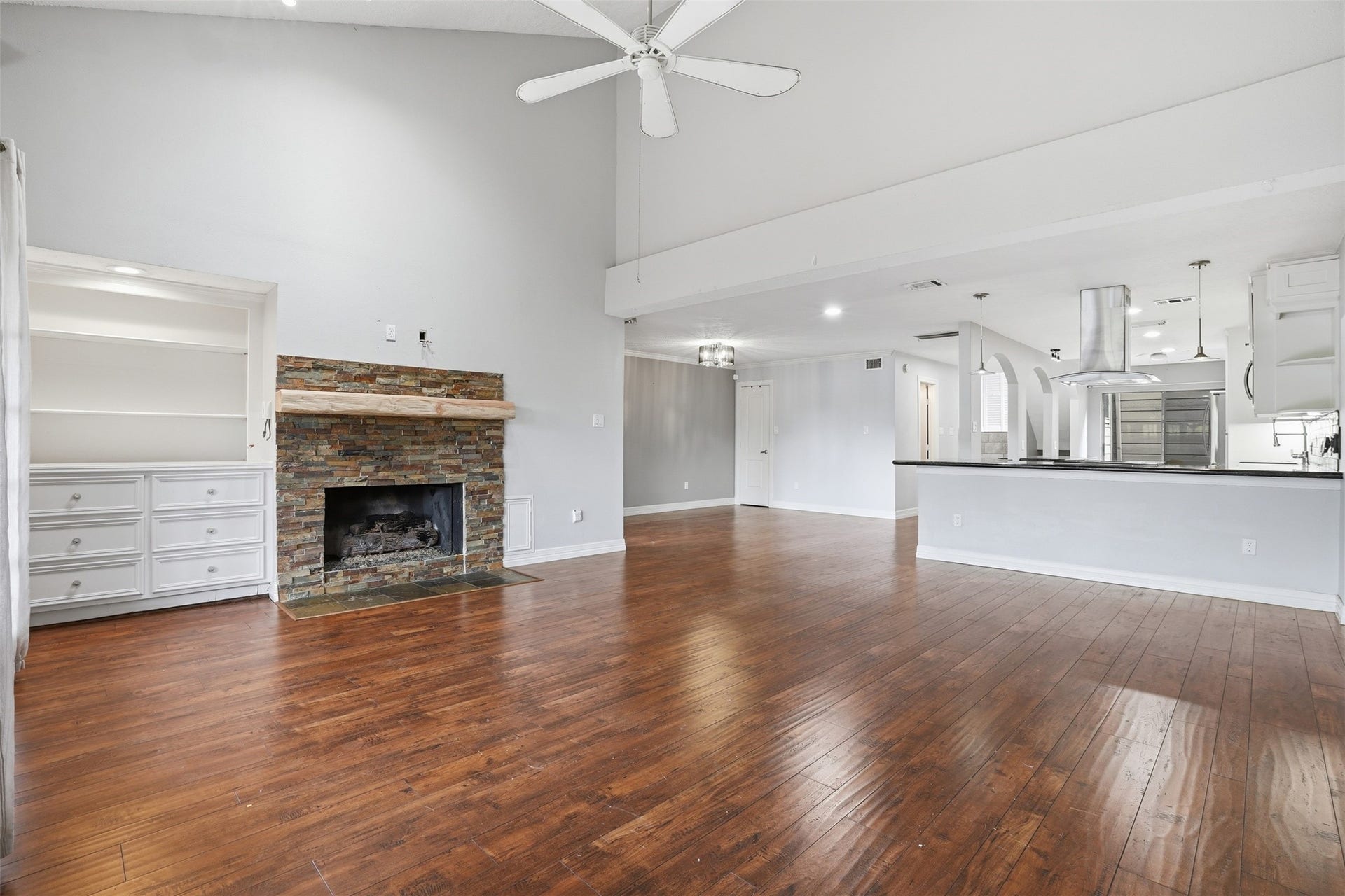 18024 Starboard Drive, Houston, TX 77058 Built in shelving adds style and function, while the room flows seamlessly into the modern kitchen featuring a large island and pendant lighting, perfect for entertaining.