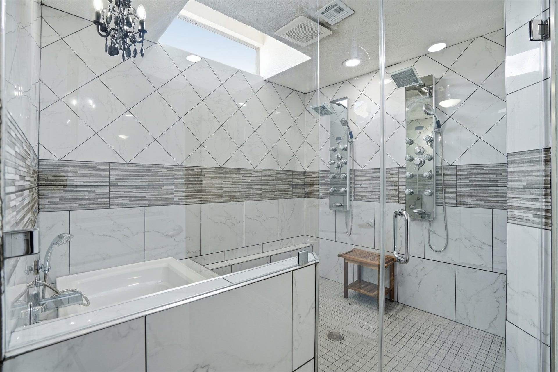 18024 Starboard Drive, Houston, TX 77058 Primary bath features a glass enclosed shower with dual rainfall showerheads, soaking tub, skylight, and elegant finishes throughout.