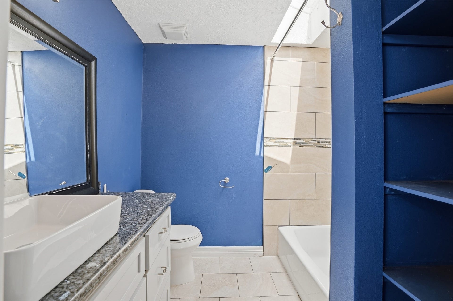 18024 Starboard Drive, Houston, TX 77058 Bright bathroom located off the secondary bedroom, featuring a modern vanity with sink and granite countertop.