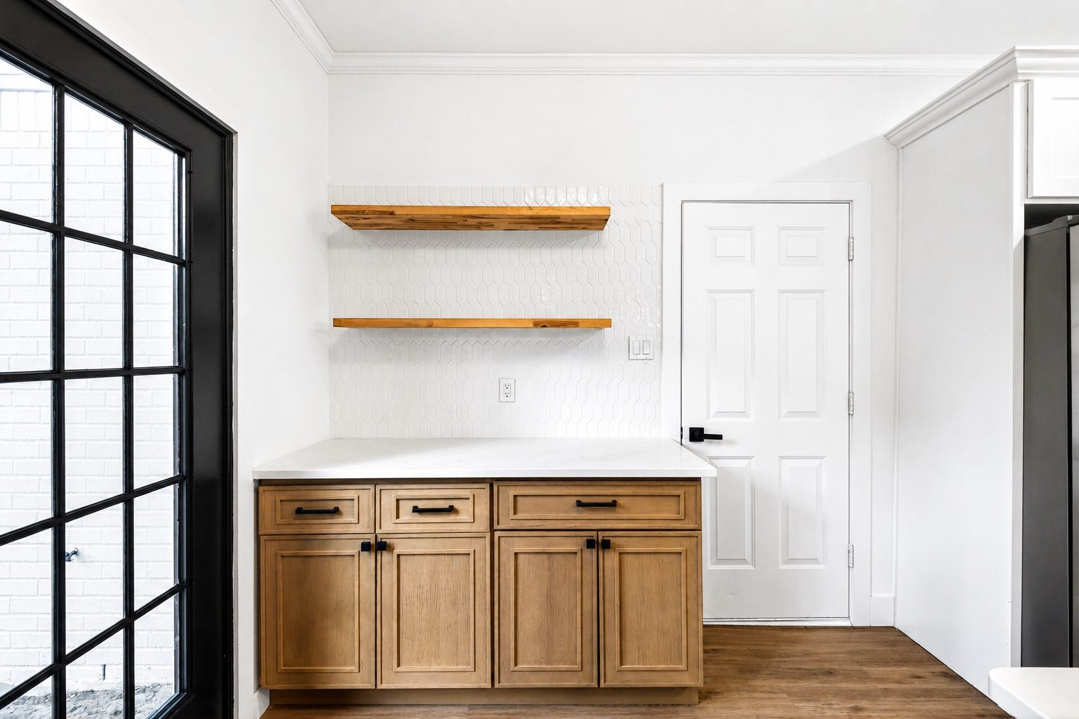 523 Rampart Lane, Conroe, TX 77302 Charming kitchen nook featuring sleek wooden cabinets, open shelving, and a stylish white backsplash.